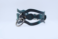 A dark green leather choker necklace with a metal ring and a metal clasp.