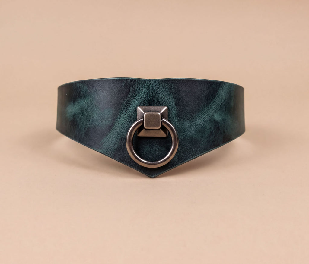 A dark green leather choker necklace with a metal ring and a square-shaped metal piece on the front.