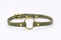 A green leather choker collar with a gold-colored metal ring and two gold-colored metal fasteners.