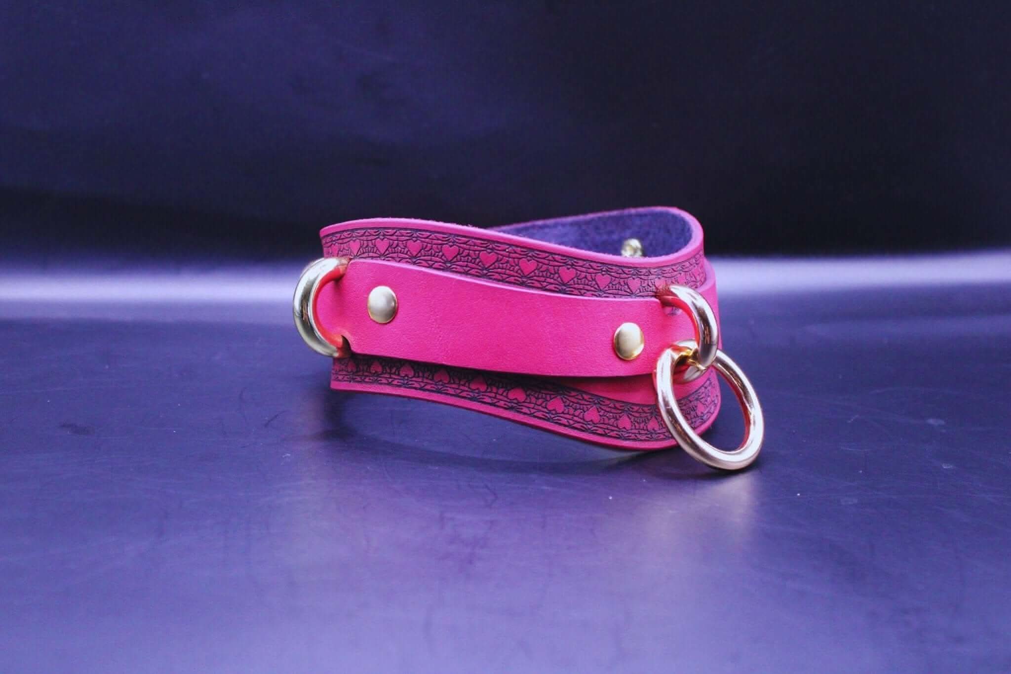 Discreet pink BDSM collar with gold hardware, perfect for submissive jewelry and bondage gear.