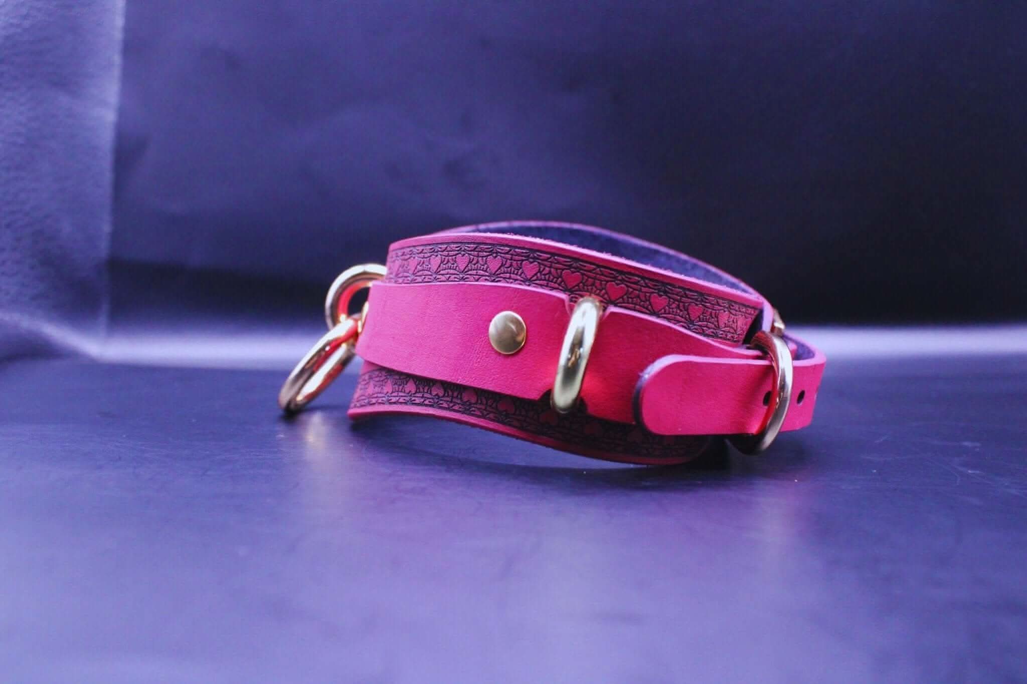 Elegant pink leather BDSM collar with gold accents, perfect for discreet submissive jewelry and bondage gear.