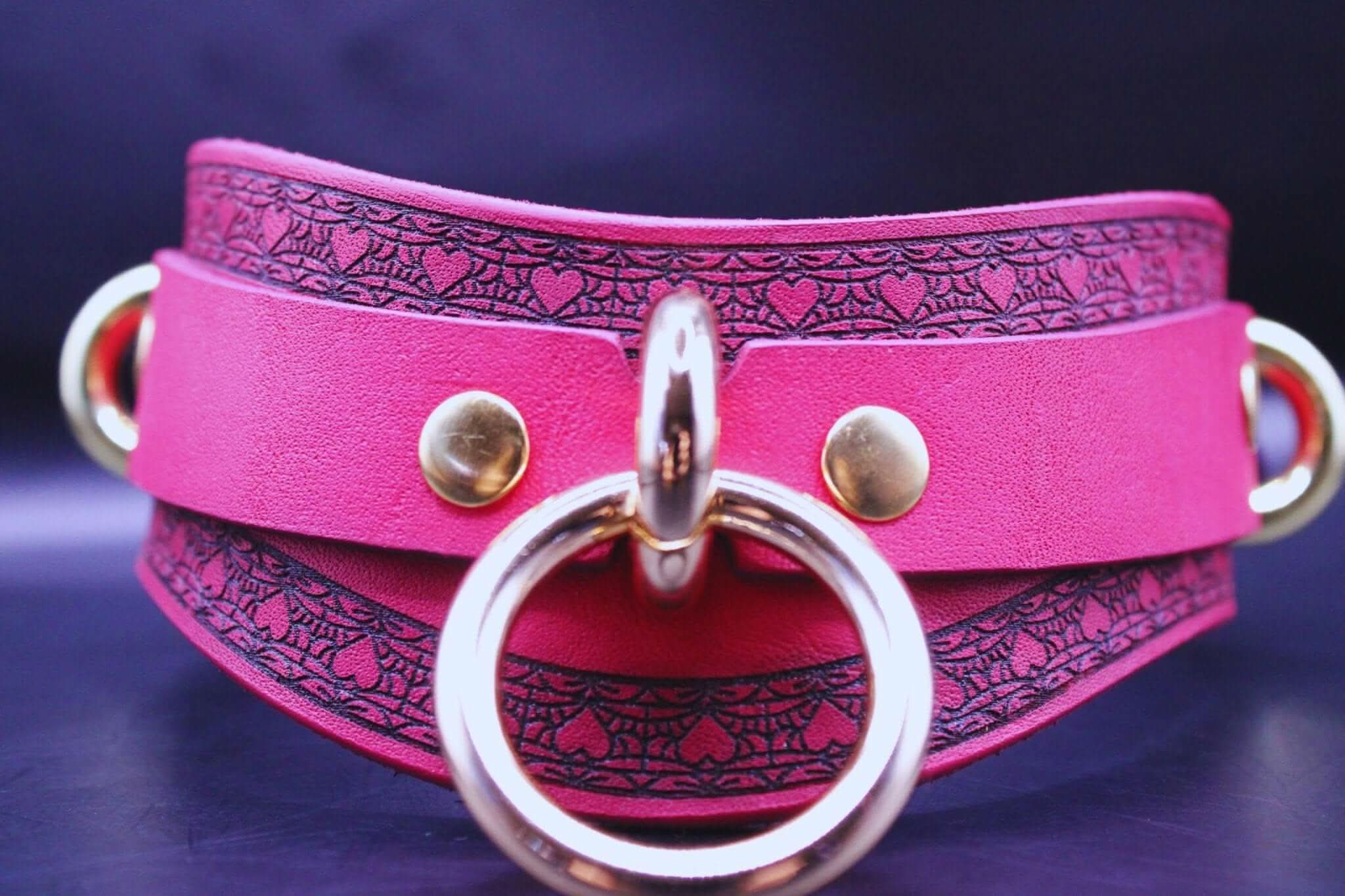 Pink leather BDSM collar with golden rings, perfect for discreet submissive jewelry and bondage wear.