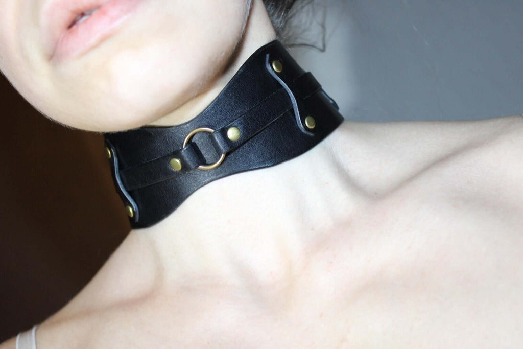 Bold black leather collar choker with O-ring, perfect for submissive and BDSM fashion scenes.