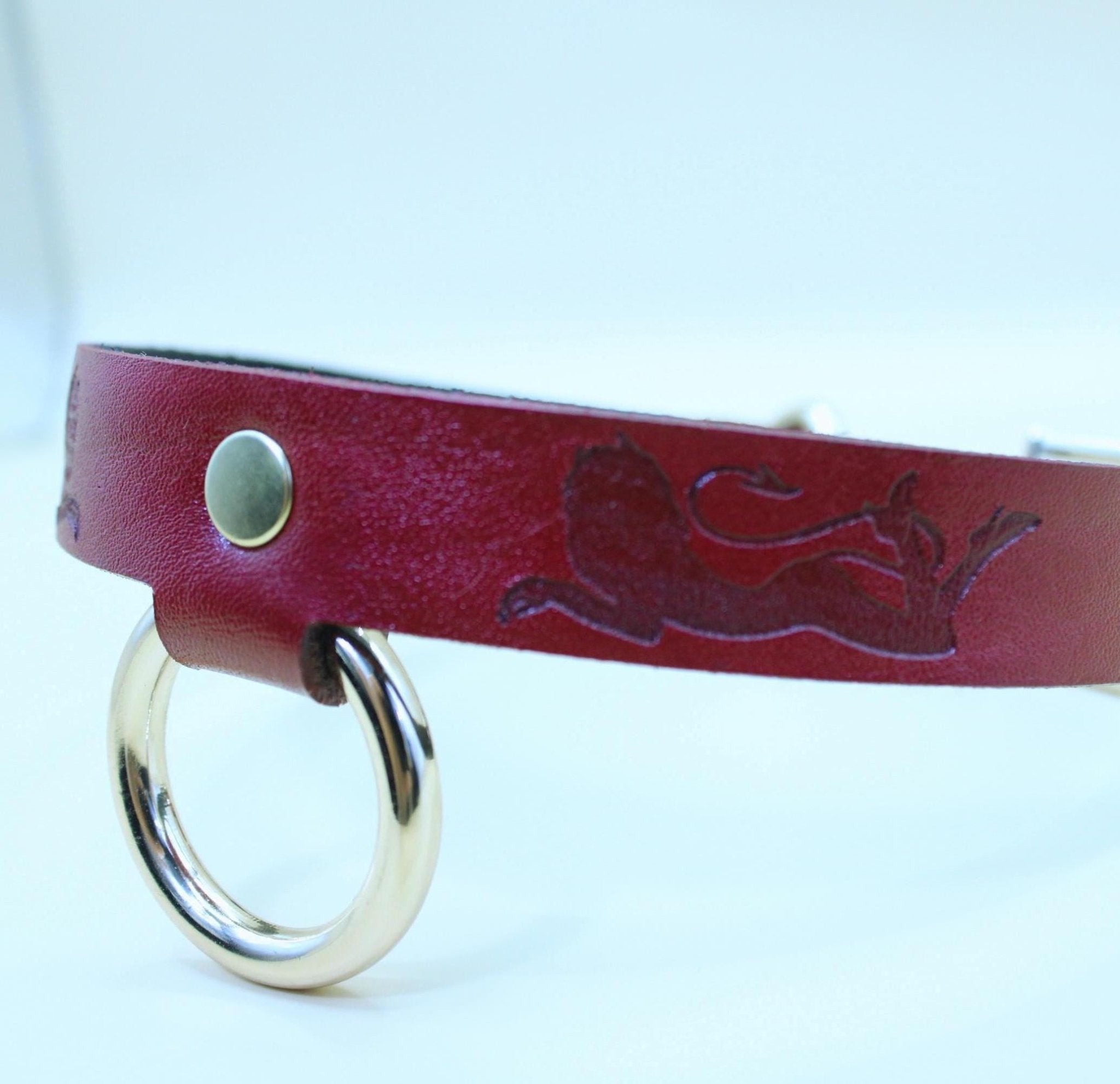 Red leather BDSM collar featuring a lion design and gold ring, perfect for bondage and submissive fashion.