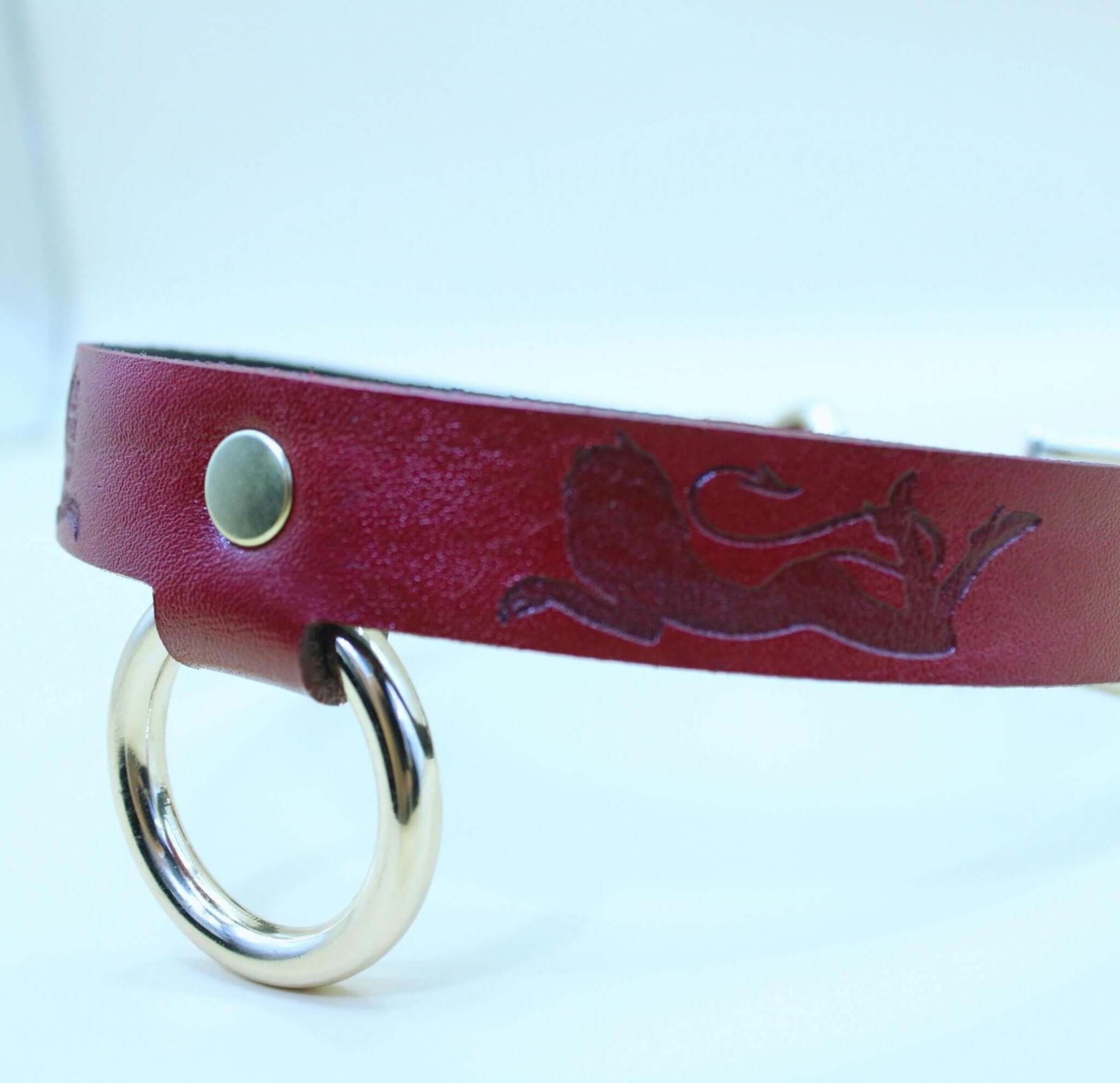Red leather BDSM collar with lion design and gold ring, perfect for submissive jewelry and bondage fashion.