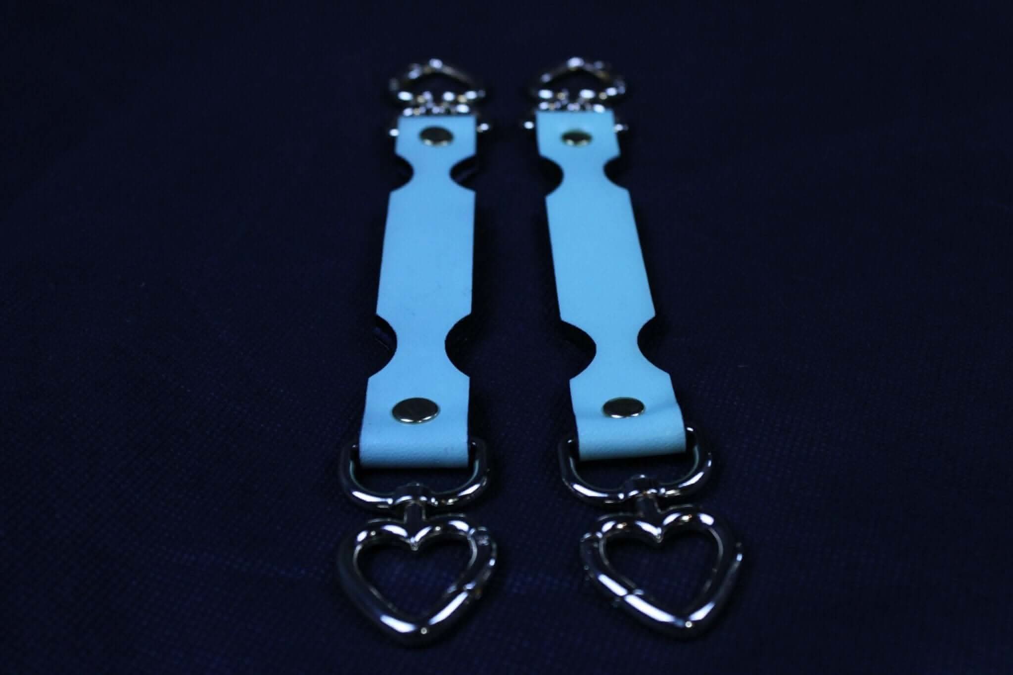 Light blue connector straps with heart-shaped metal clips, perfect for bondage gear and BDSM accessories.