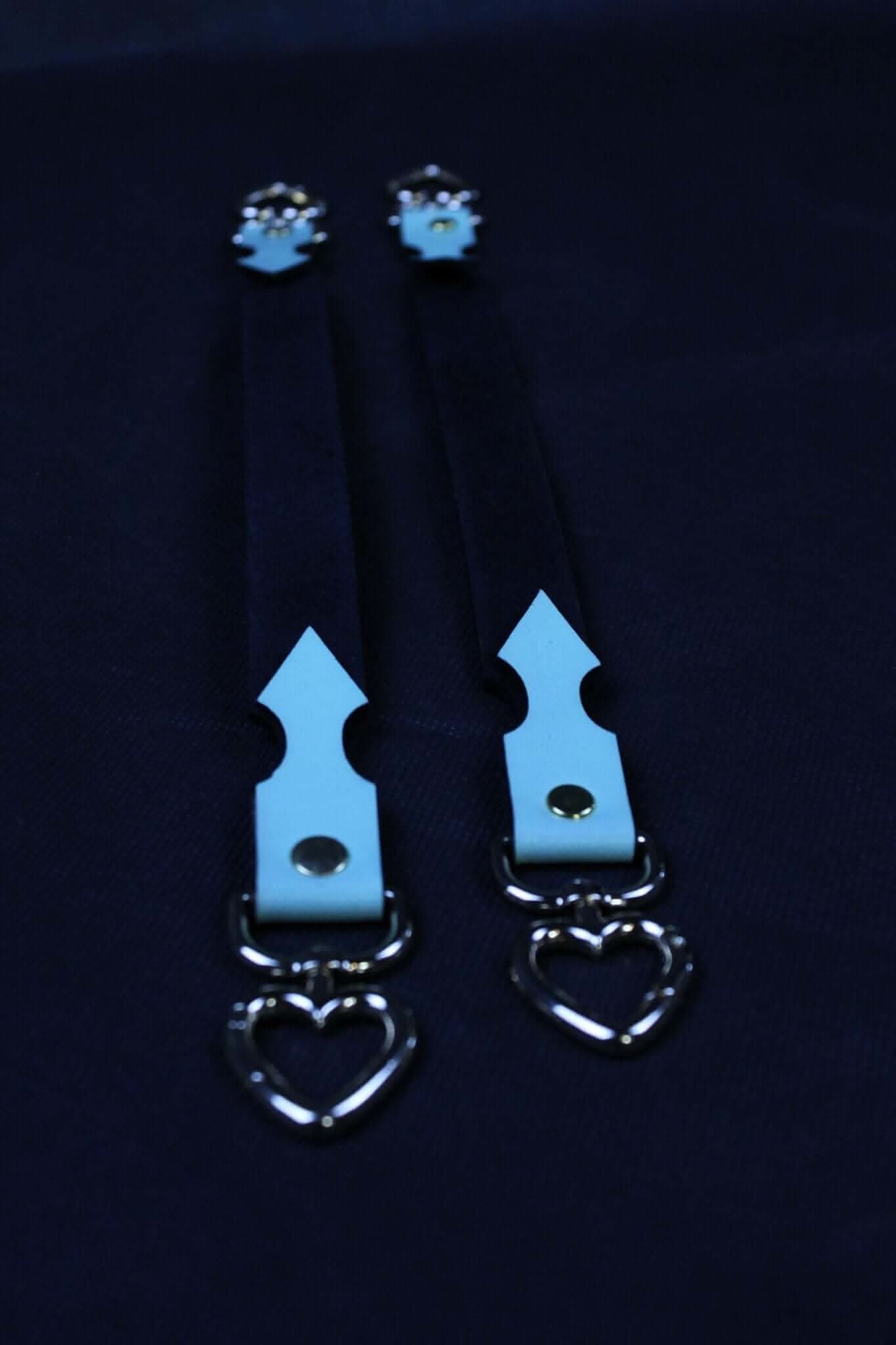 Blue leather connector straps with heart-shaped clasps for BDSM bondage gear and accessories.
