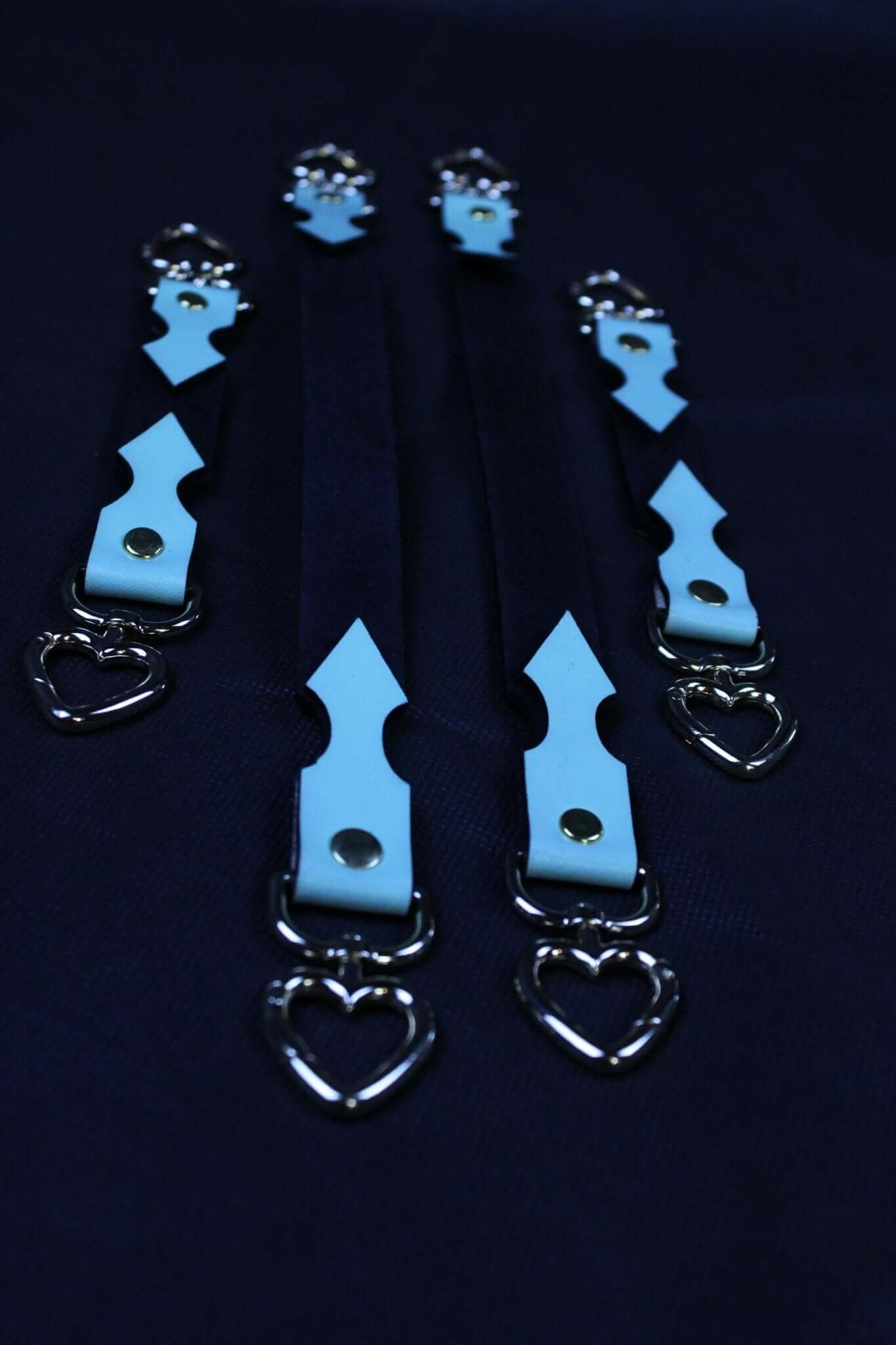 BDSM connector straps in black and light blue with heart-shaped clips for bondage gear and restraint accessories.