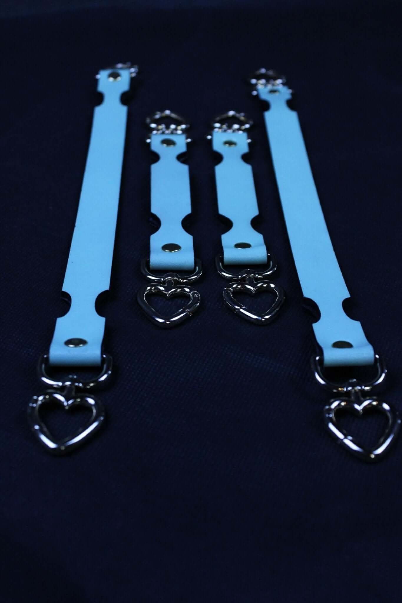 Set of blue connector straps featuring heart-shaped clips for BDSM restraint, suitable for cuffs and collars.