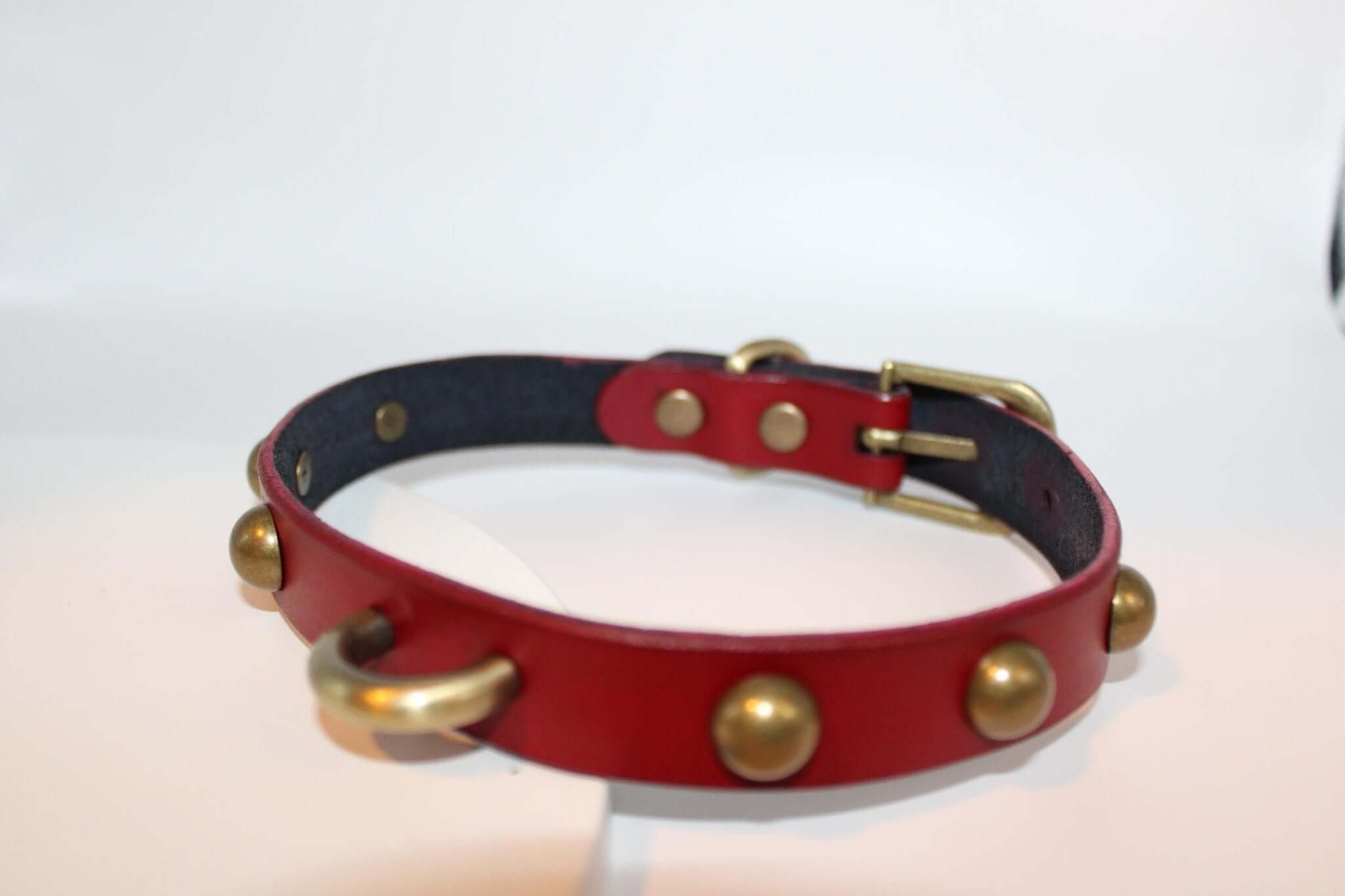 Bold red leather BDSM collar with antique brass studs and D-ring for submissive jewelry and bondage gear.