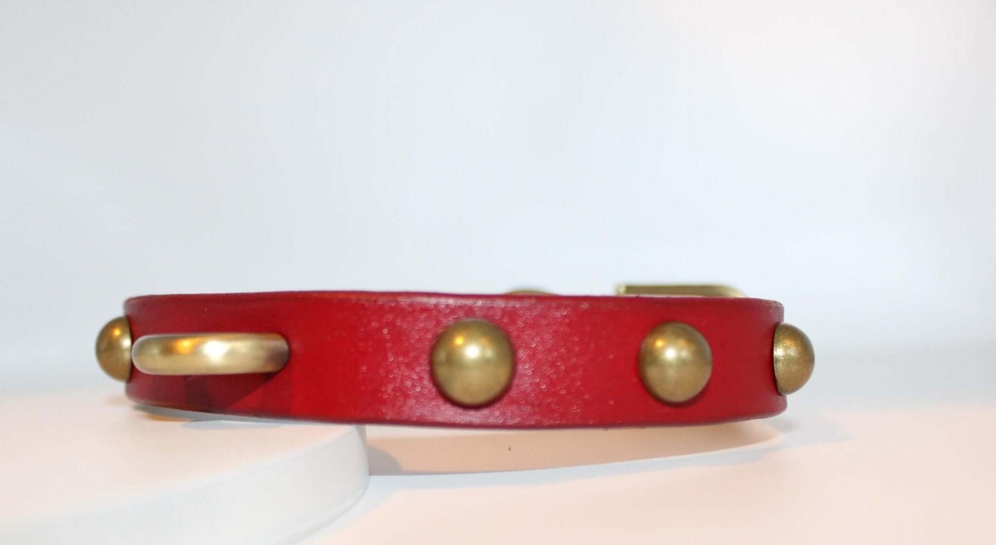Bold red leather BDSM collar with antique brass studs, ideal for submissive jewelry and alternative fashion enthusiasts.