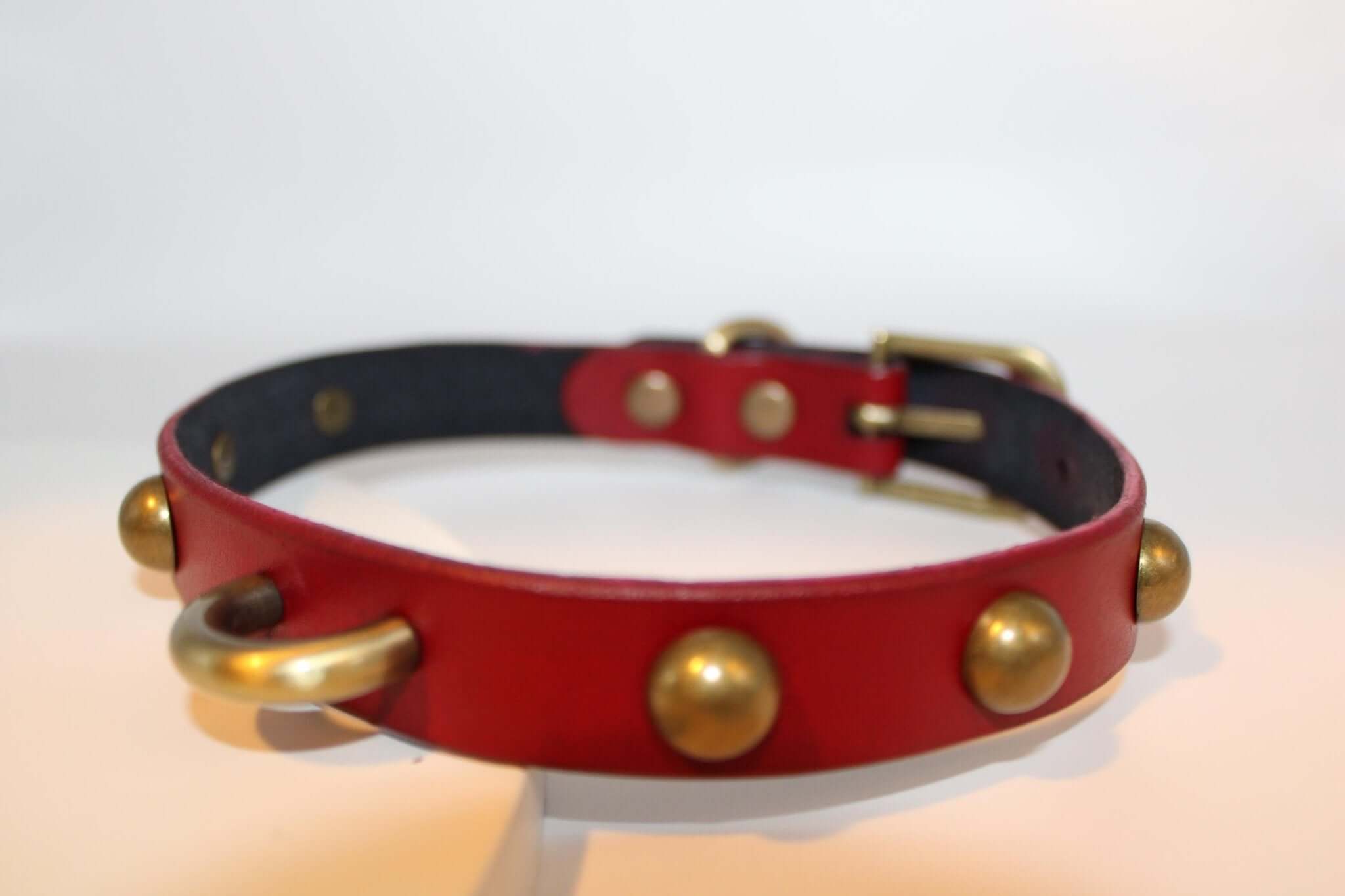 Red leather studded collar with D-ring, ideal for BDSM, submissive jewelry, and alternative fashion.