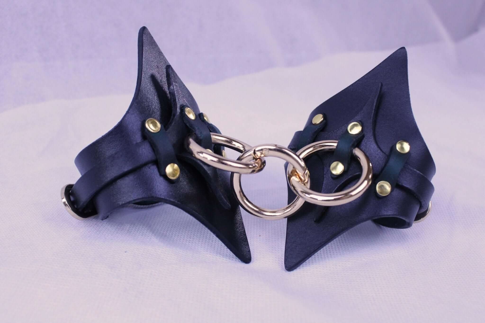 Handmade leather BDSM handcuffs with brass hardware, perfect for bondage play and submissive fantasies.