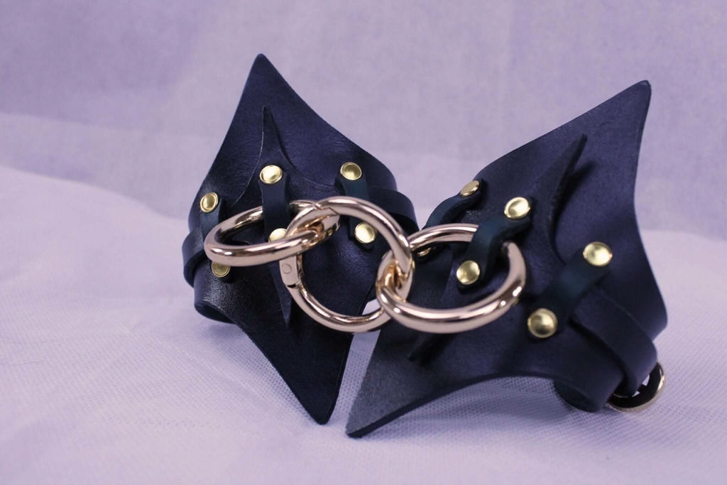 Handmade leather handcuffs with gold hardware, perfect for BDSM play and bondage gear, ideal for submissive fantasies.