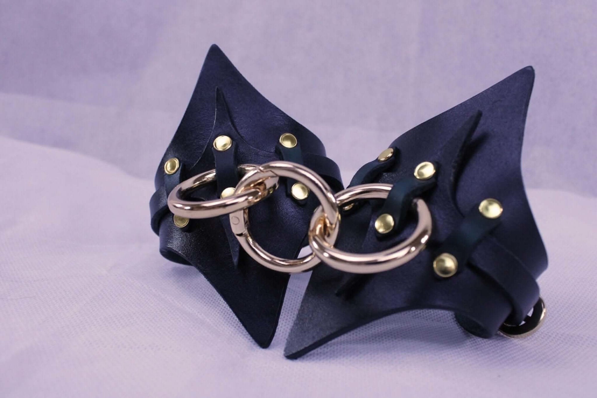 Handmade leather handcuffs with gold hardware, perfect for BDSM play and bondage gear, ideal for submissive fantasies.