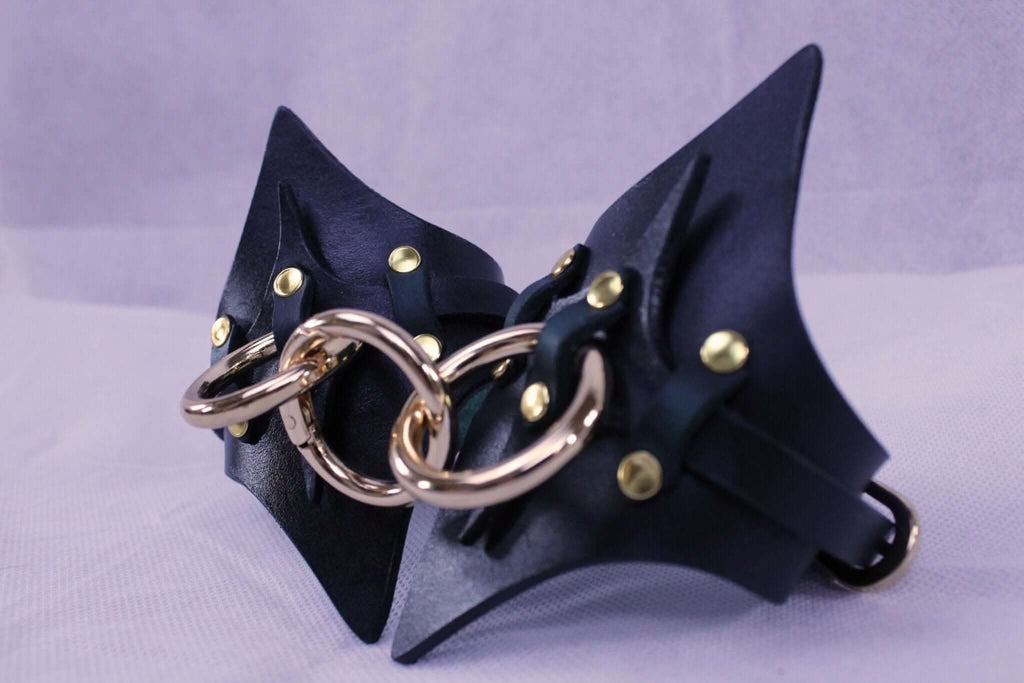 Handmade leather handcuffs featuring solid brass hardware for BDSM play and restraint.