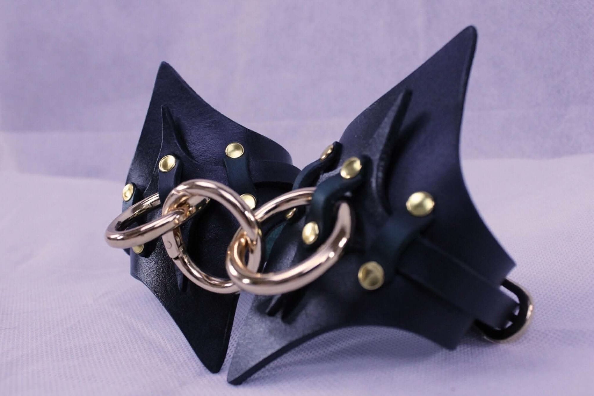 Handmade leather handcuffs featuring solid brass hardware for BDSM play and restraint.