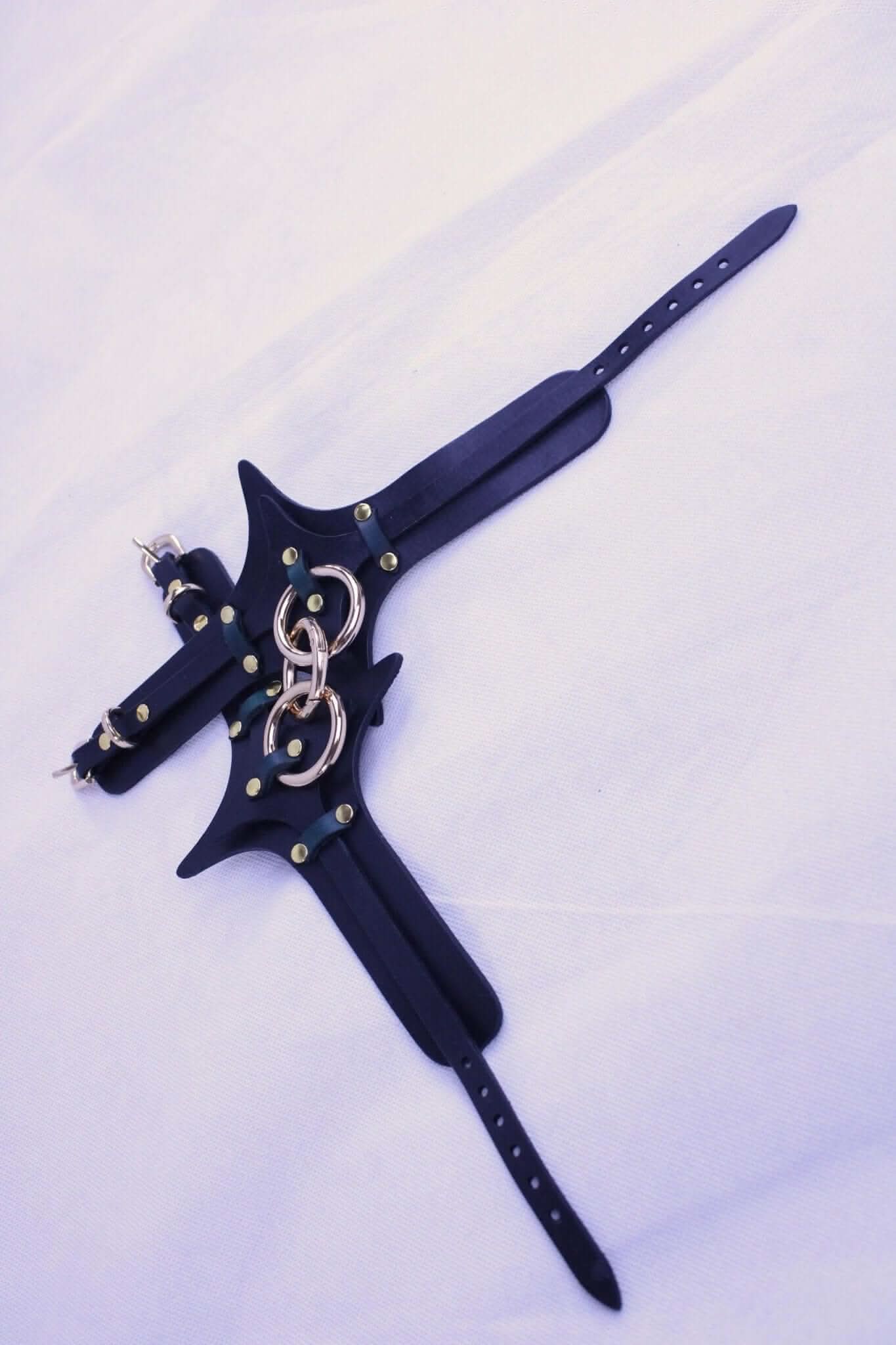 Handmade leather BDSM harness with brass hardware for bondage play and submissive experiences.