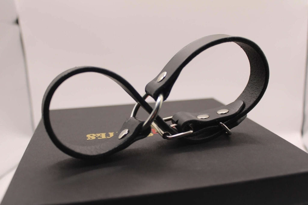 Black leather handcuffs for bondage play, ideal for BDSM enthusiasts and intimate partner exploration.