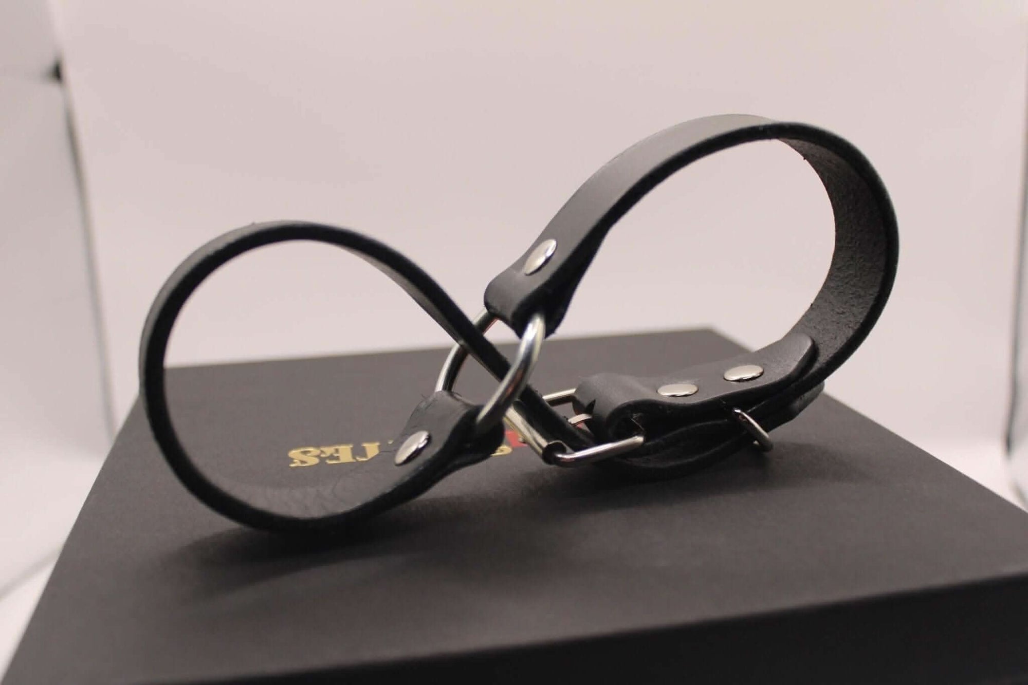 Black leather handcuffs for bondage play, ideal for BDSM enthusiasts and intimate partner exploration.