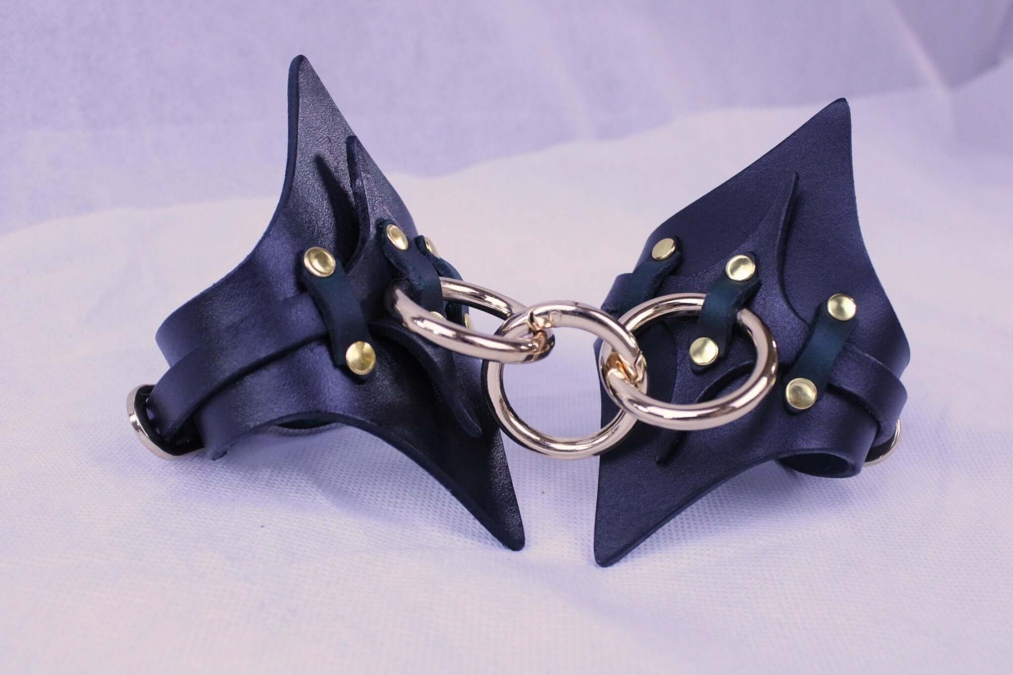 Premium BDSM leather handcuffs with gold accents, designed for comfort and durability in bondage play.