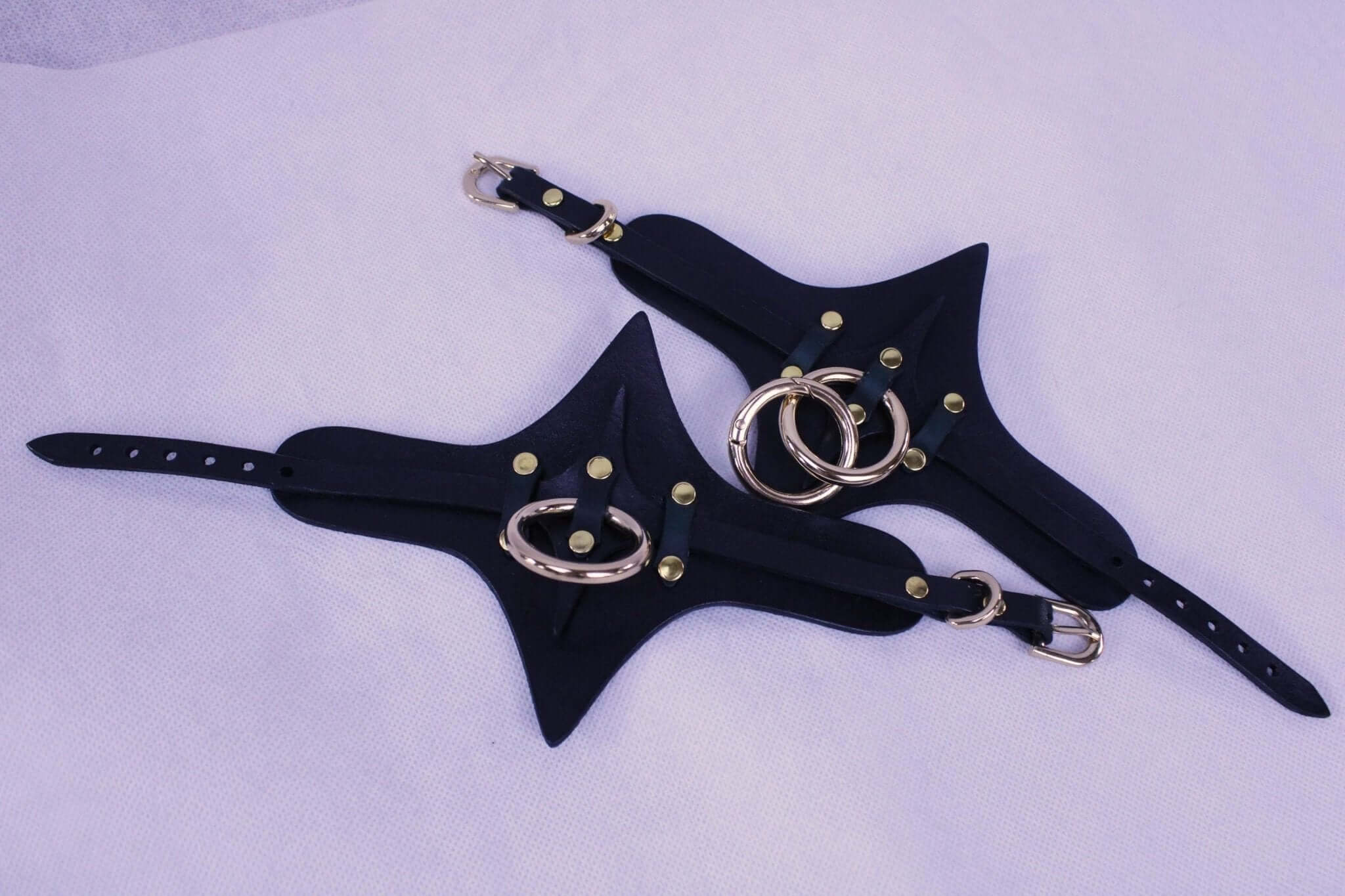Premium BDSM leather cuffs with gold rings, adjustable straps, perfect for bondage gear and submissive jewelry.