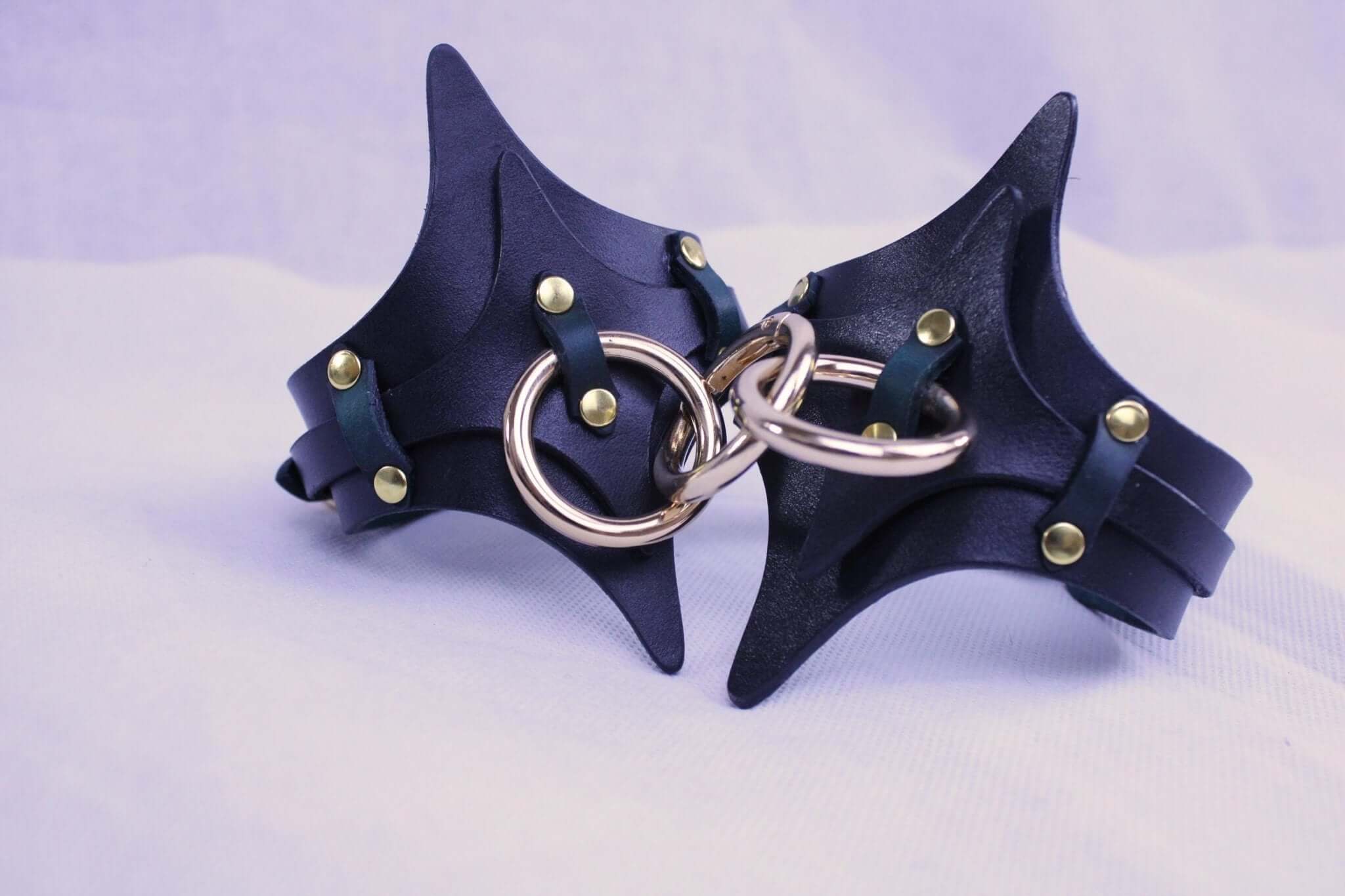 Premium BDSM leather handcuffs with gold accents, designed for comfort and adjustable fit, perfect for bondage gear.