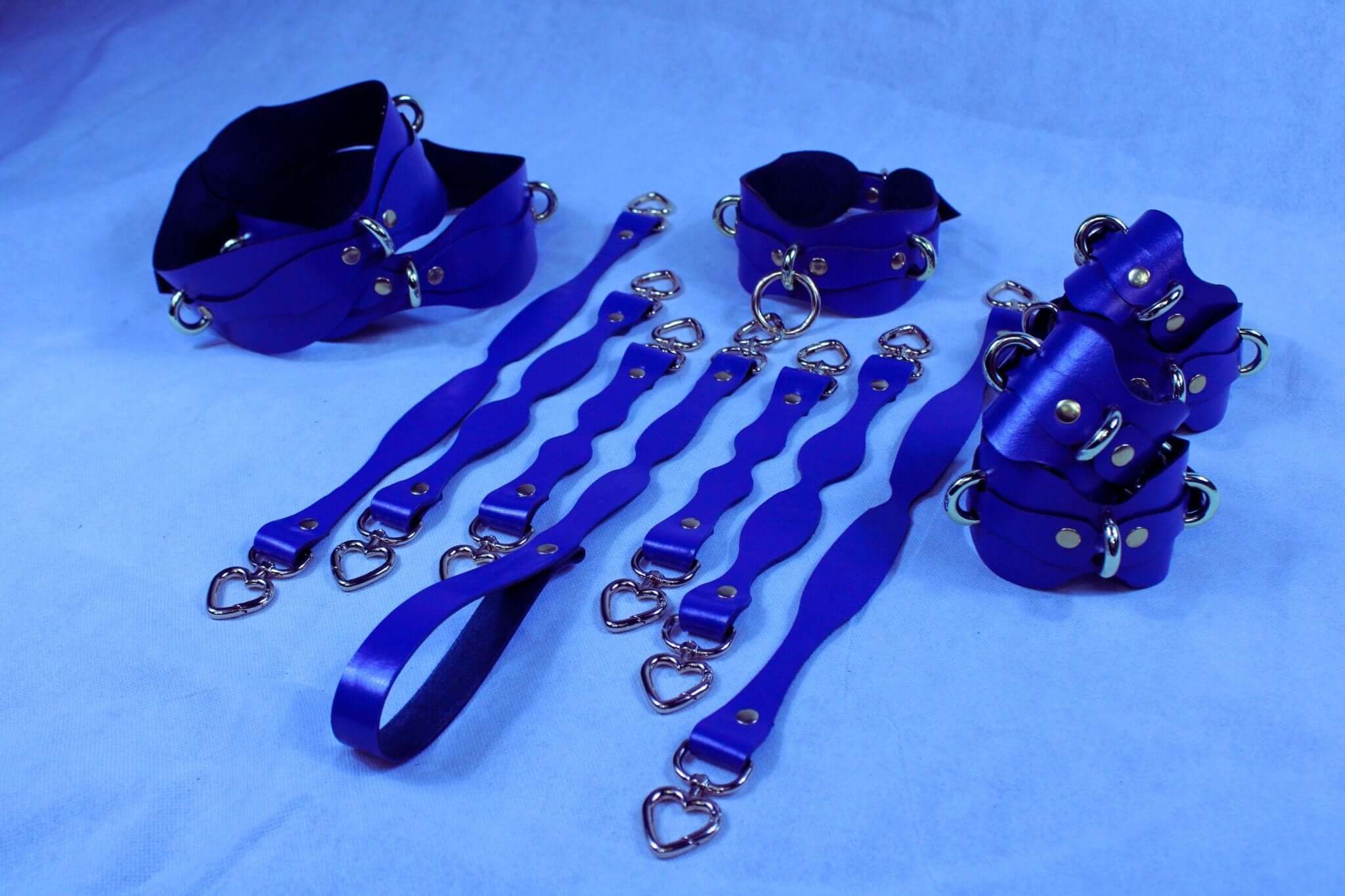 Handmade blue leather BDSM restraint kit featuring collars and cuffs for sub and dom play, enhancing bondage experience.