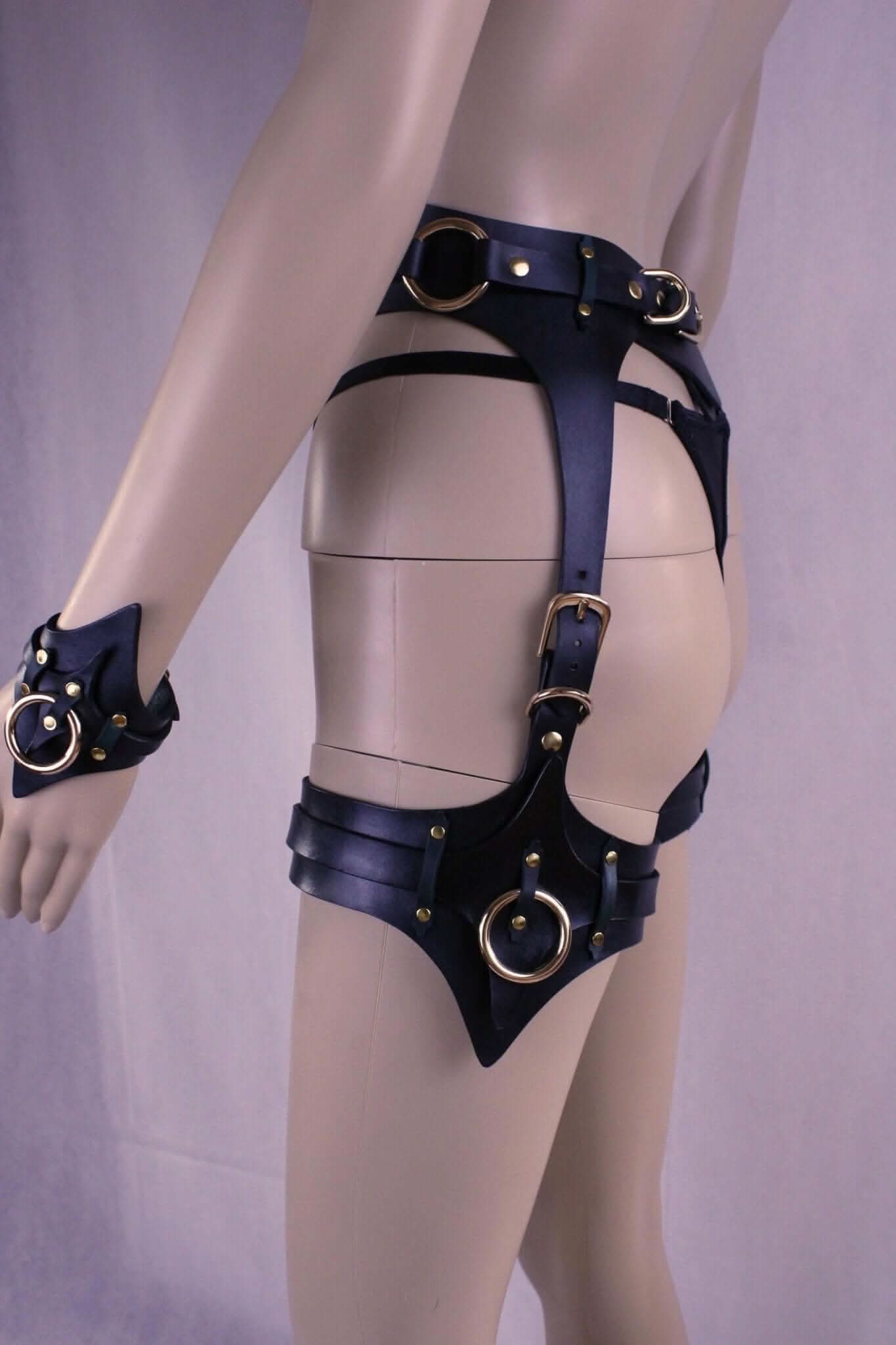 Leather thigh harness and cuffs set showcasing BDSM gear for submissive lingerie, featuring premium Italian leather and golden accents.