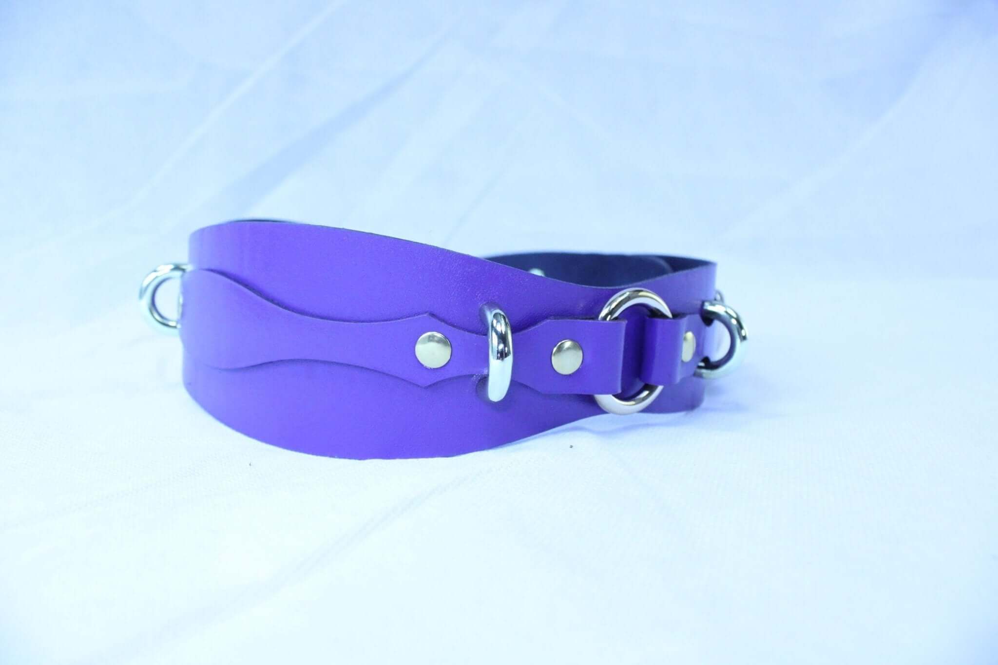 Purple leather waist belt with D-rings for BDSM gear, adjustable restraint harness accessory for bondage control.