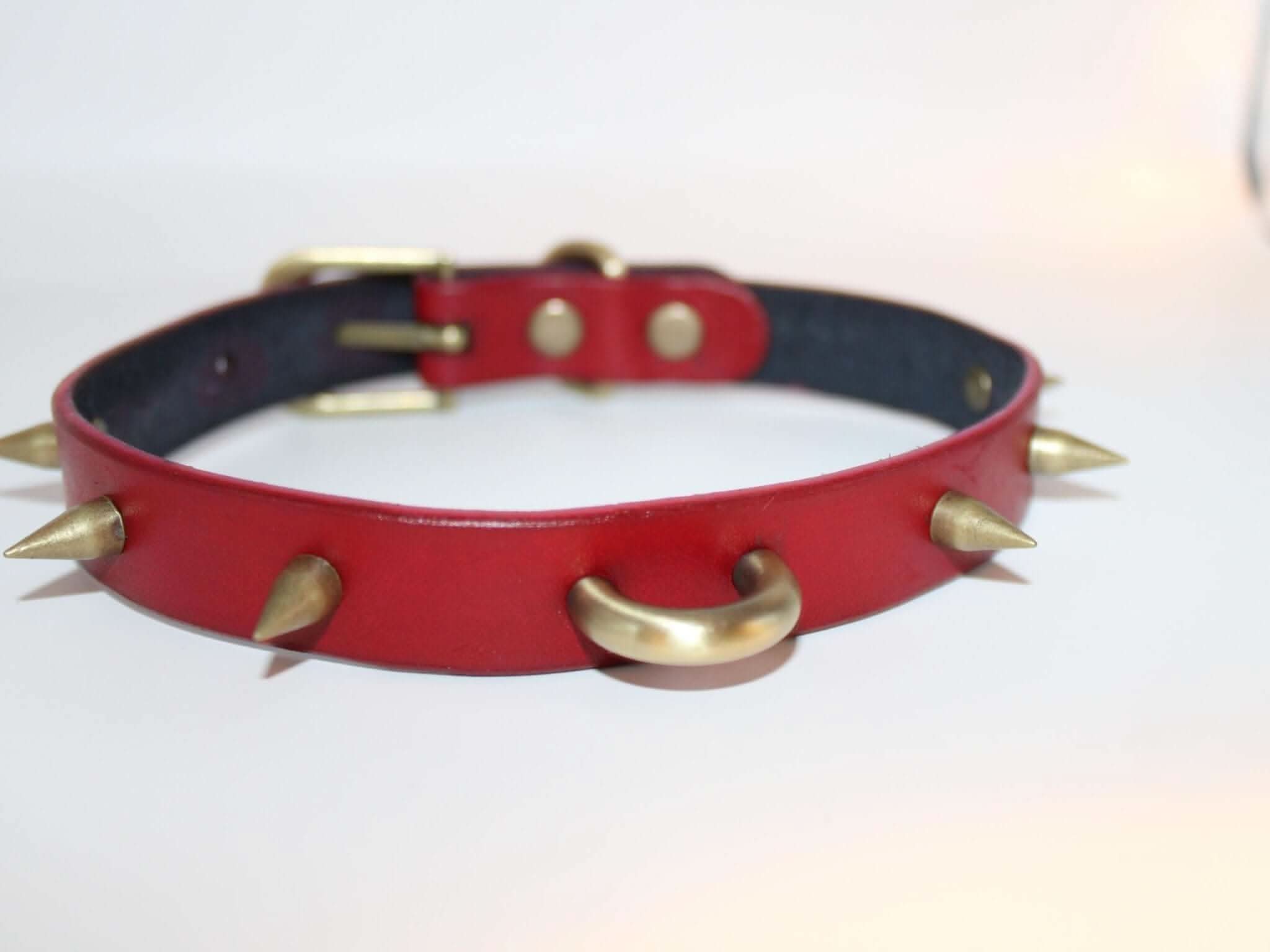 Spiked red BDSM collar with gold O-ring and metallic spikes, ideal for punk style and bondage fashion.