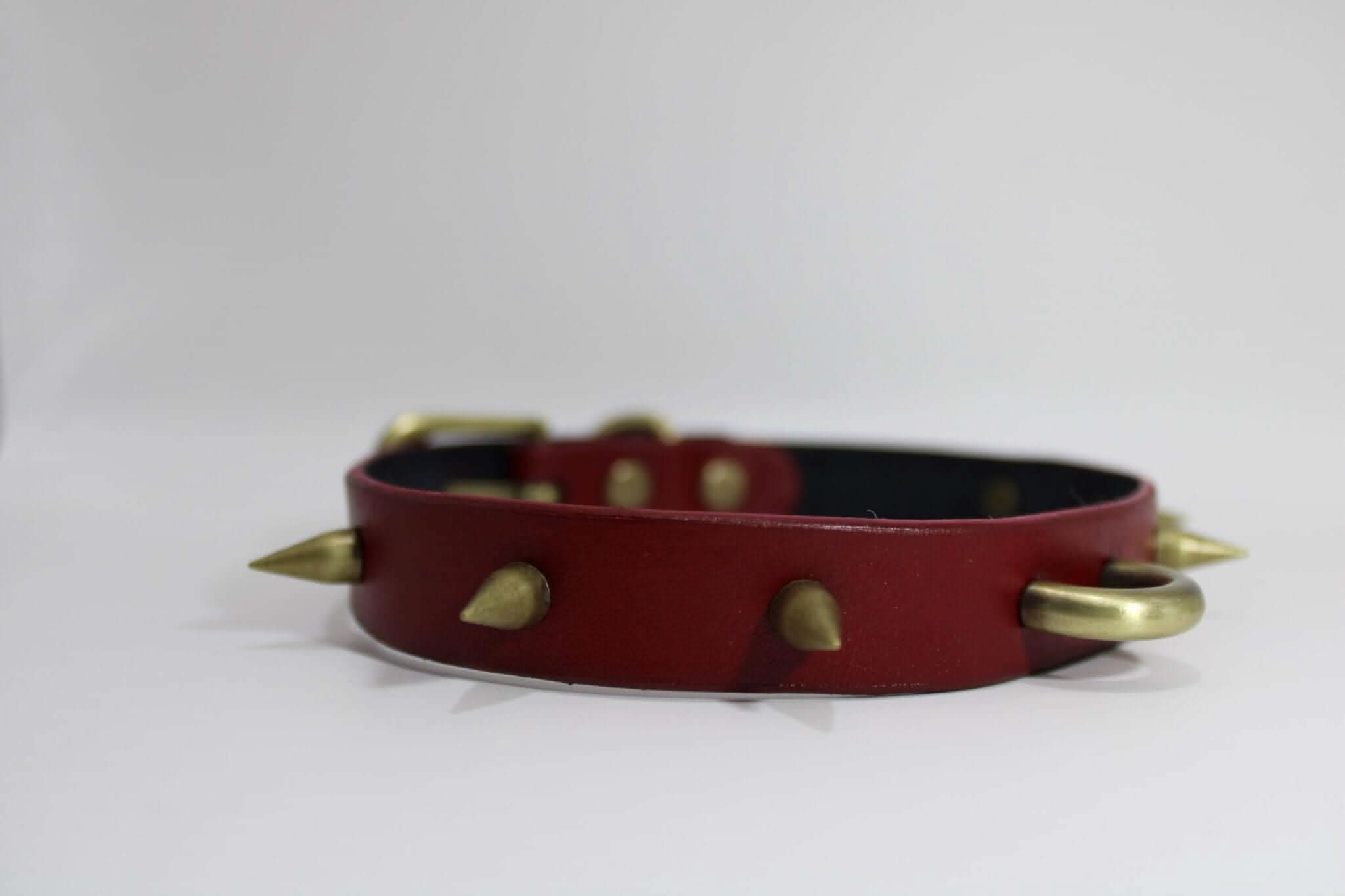 Spiked heavy-duty BDSM collar in red leather with metallic O-ring and spikes, perfect for punk and fetish fashion.