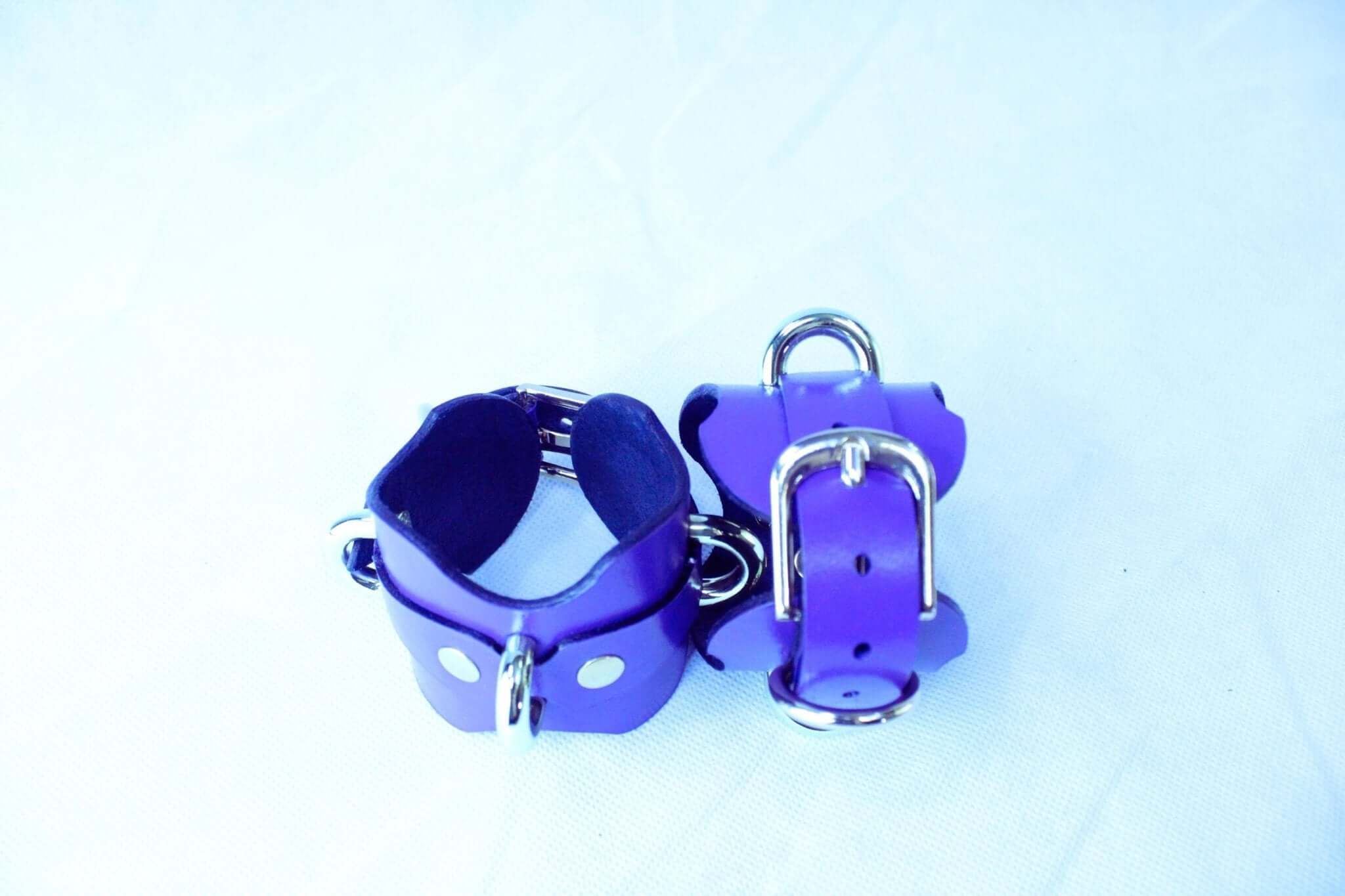 Purple handmade leather wrist cuffs with D-rings for bondage and restraint, perfect for sub collar and BDSM gear.