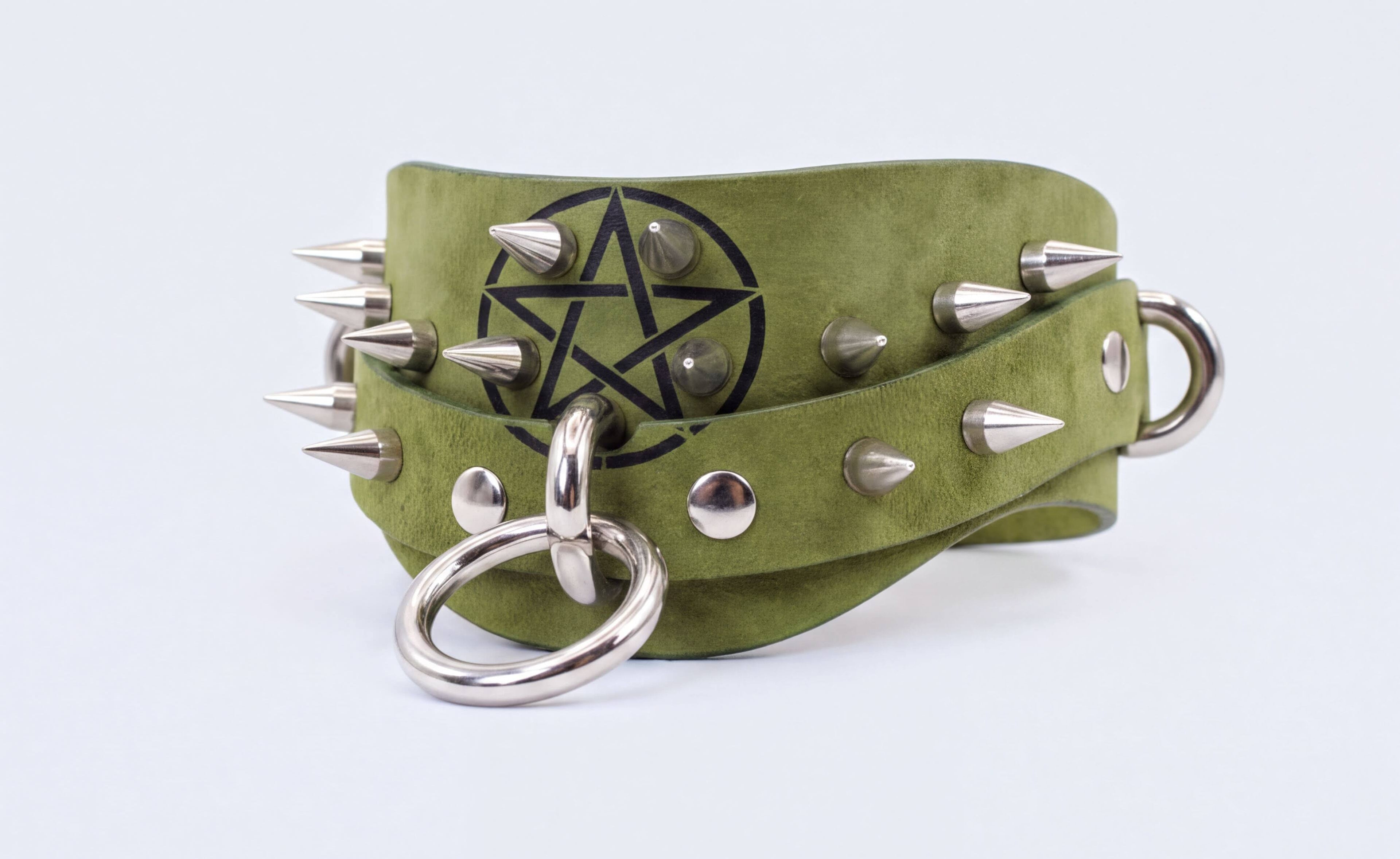 A green leather choker necklace with silver spikes and a star-shaped emblem.