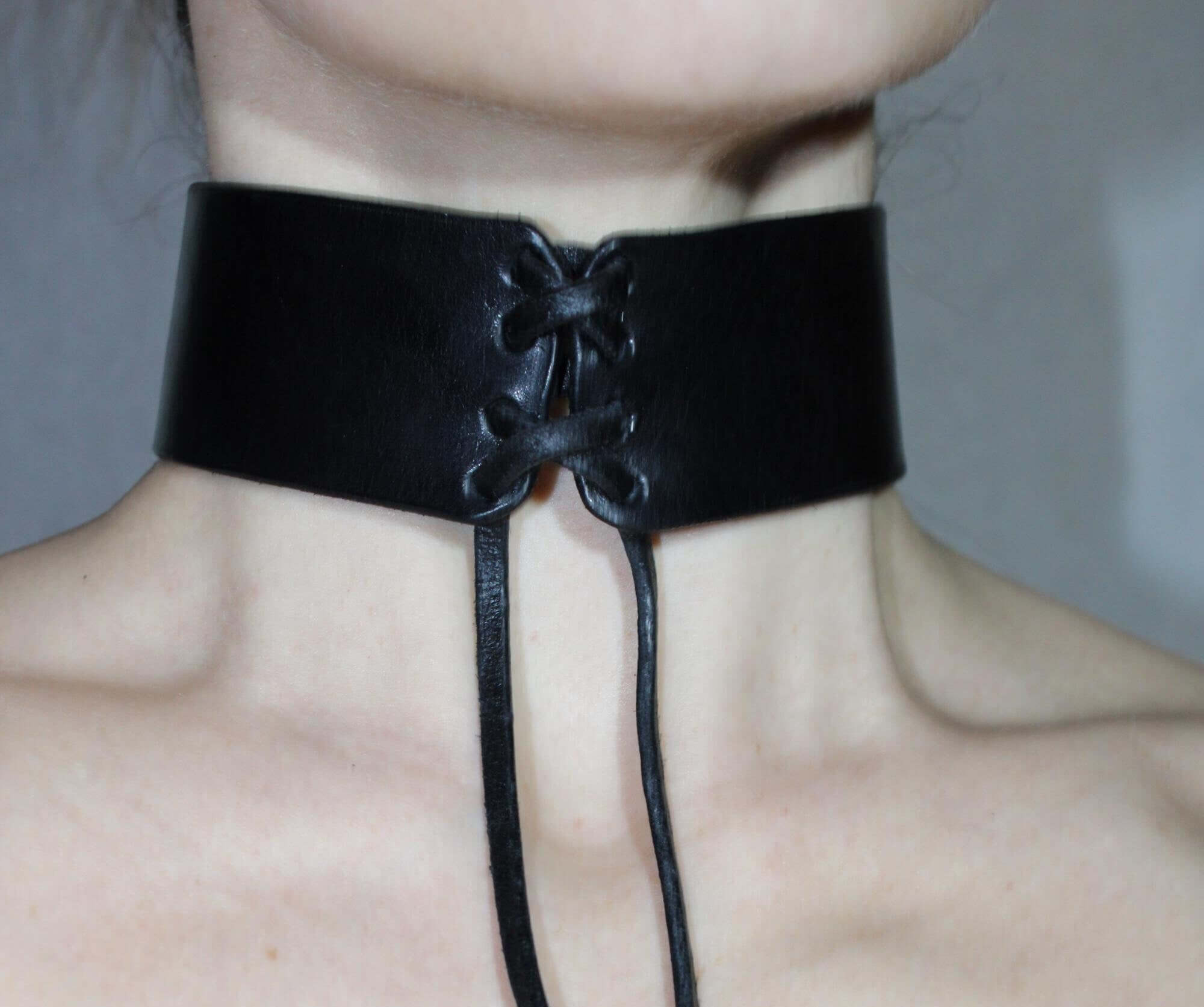 Black leather bondage choker collar with lace-up detail, designed for BDSM and roleplay enthusiasts.