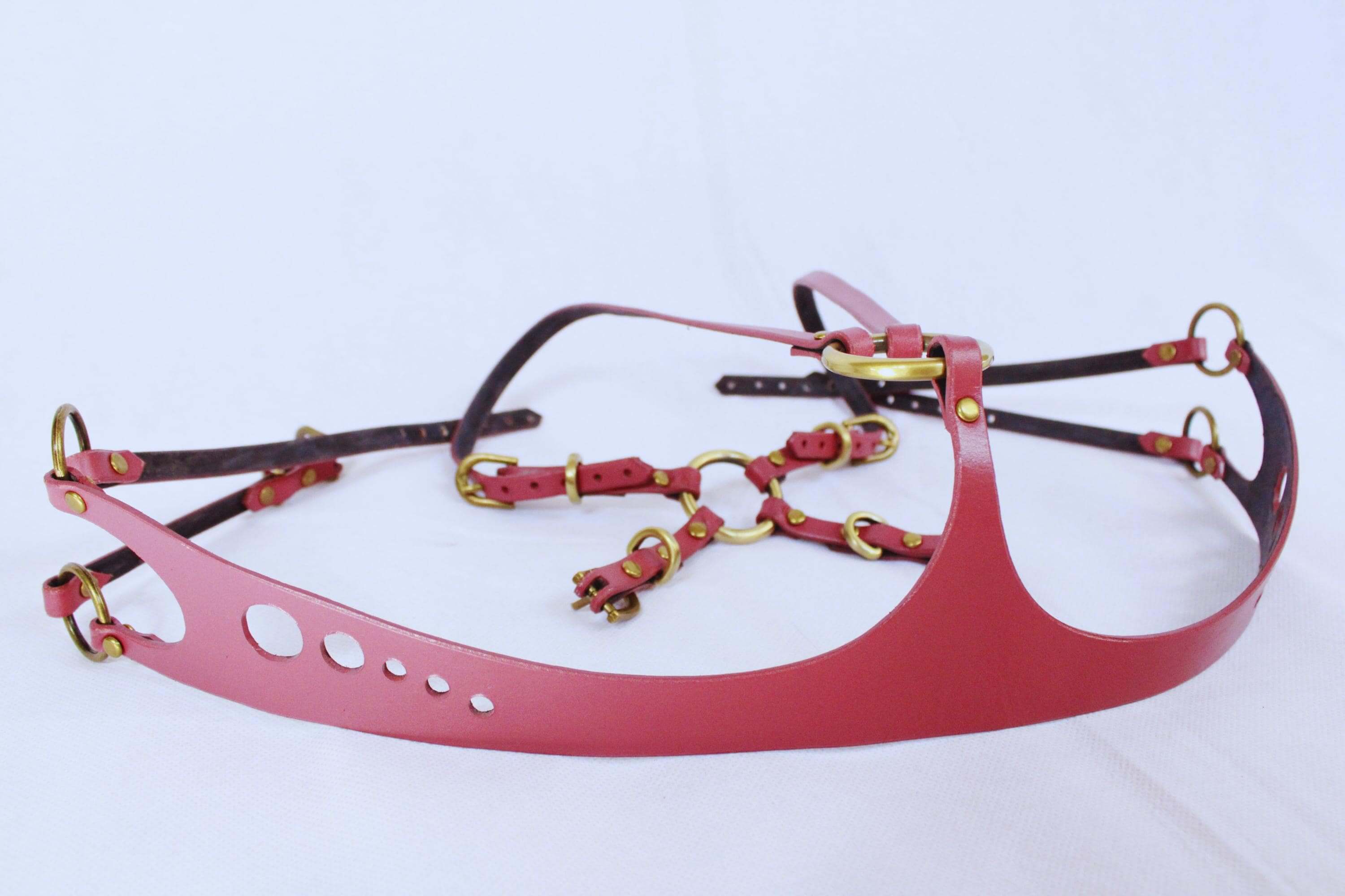 Red leather underbust BDSM harness with gold hardware, designed for bondage, lingerie, and submissive fashion.