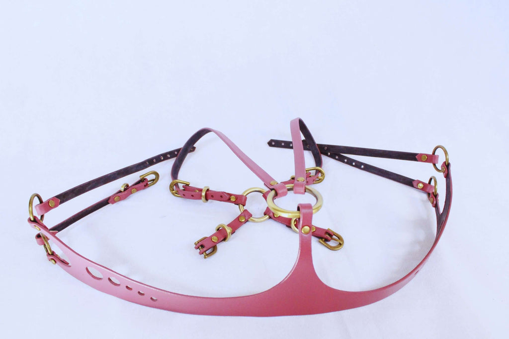 Underbust BDSM harness in pink leather, perfect for bondage gear and enhancing curves, ideal for submissive aesthetics.