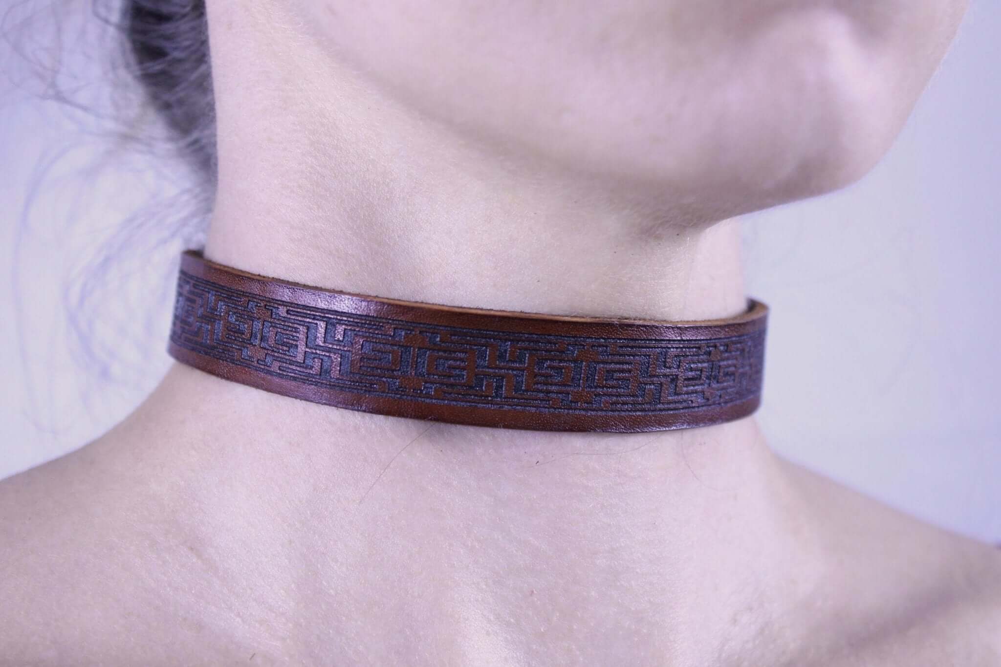 Brown leather submissive collar showcasing intricate design, perfect as discreet day collar or stylish bondage jewelry.