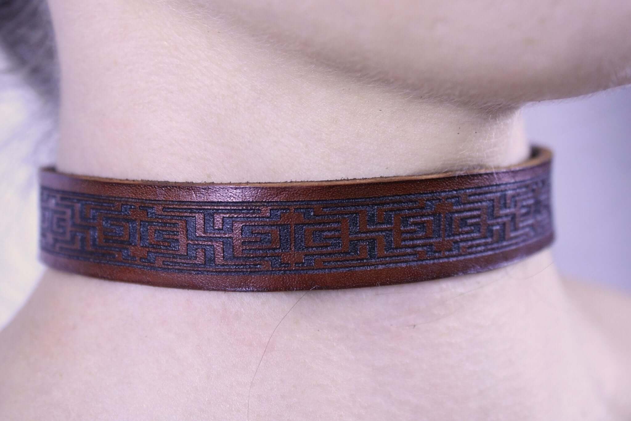 Brown leather submissive collar showcasing intricate design, perfect for BDSM jewelry and discreet daywear.