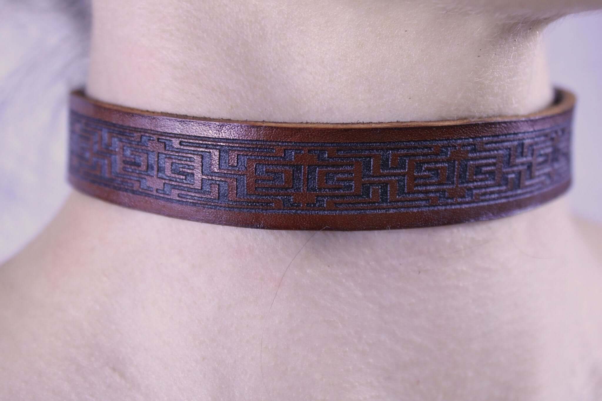 Brown leather submissive collar with intricate design, perfect for BDSM daywear and elegant accessory.