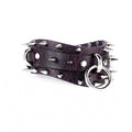 A purple leather belt with spikes and a metal ring attached to it.
