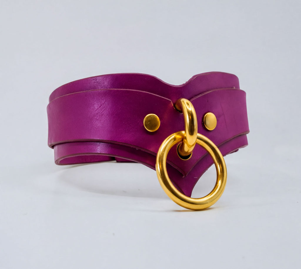 A purple leather choker necklace with a gold ring and buckle.