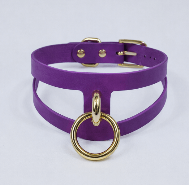 A purple choker necklace with a gold-colored metal ring and buckle.