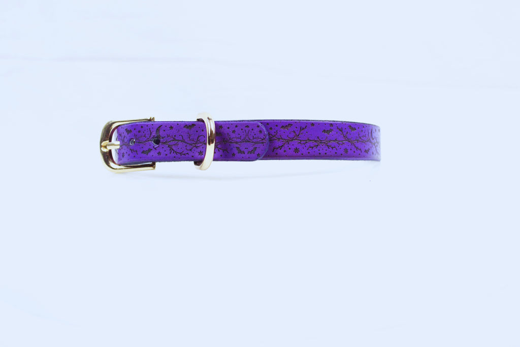 A purple leather belt with a gold buckle is shown against a white background.