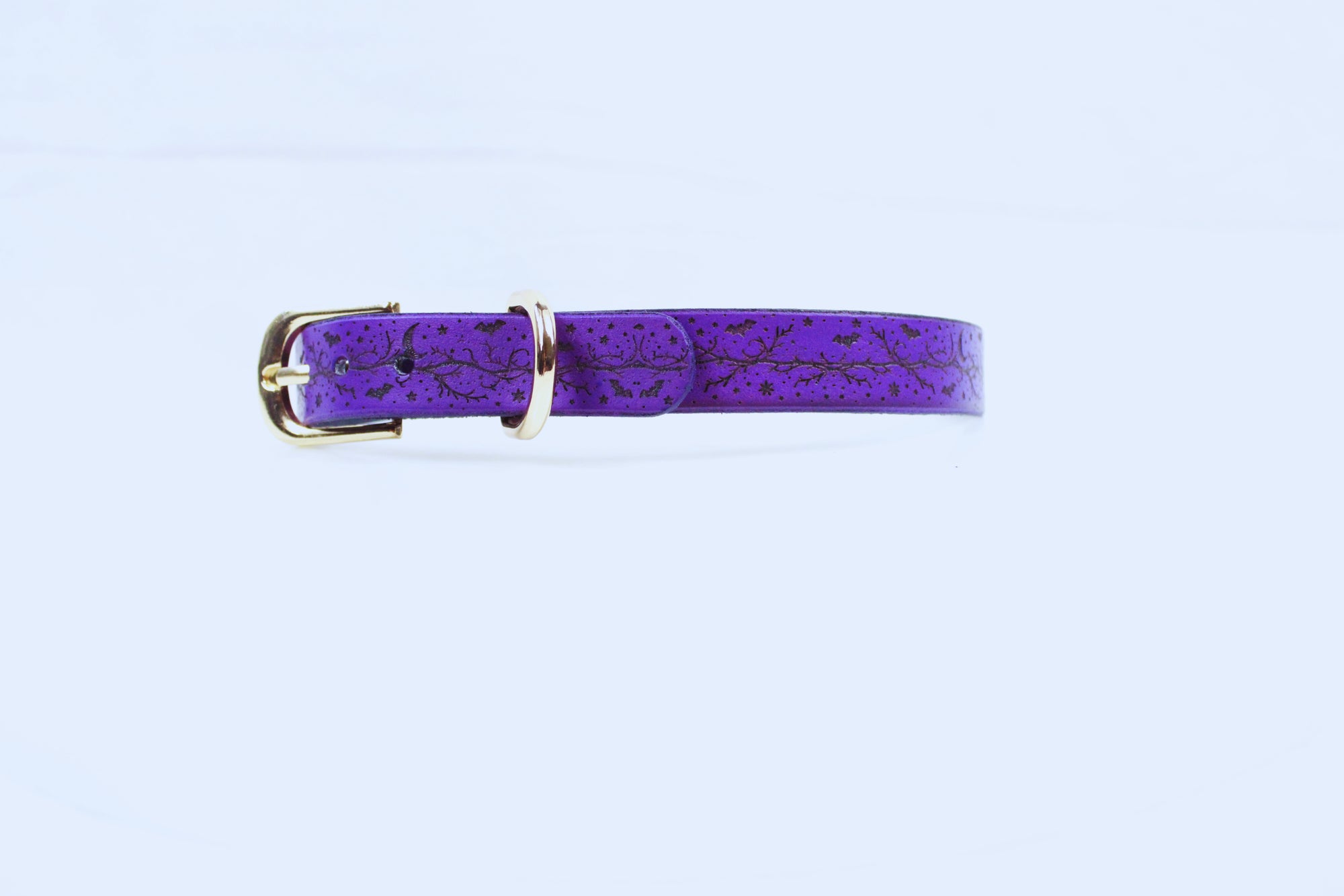 A purple leather belt with a gold buckle is shown against a white background.