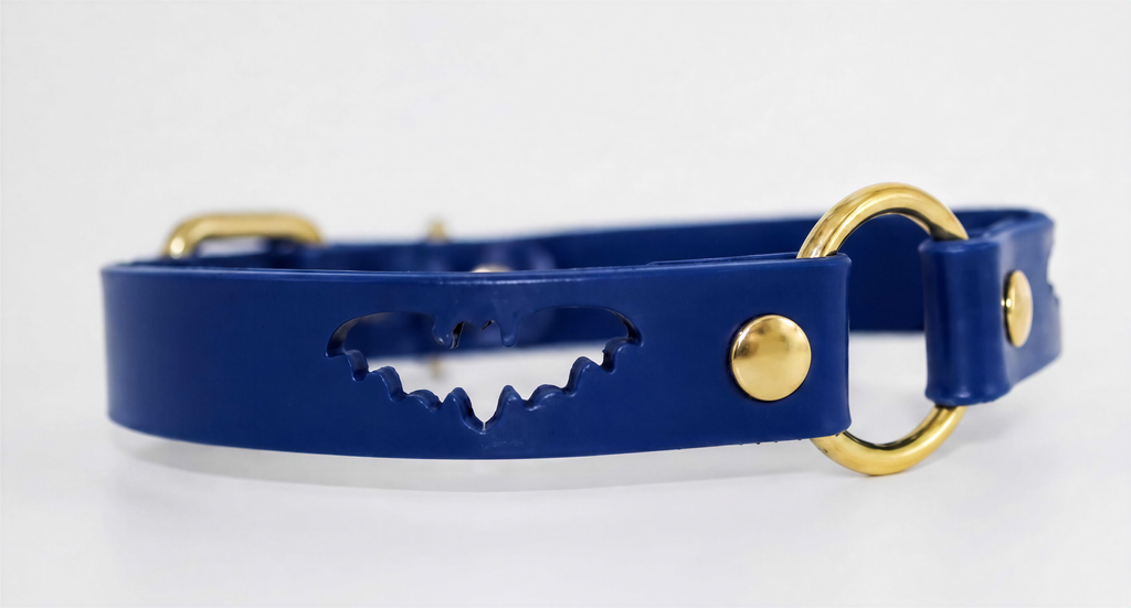 A blue leather collar with a bat-shaped cutout and two gold-colored buckles.