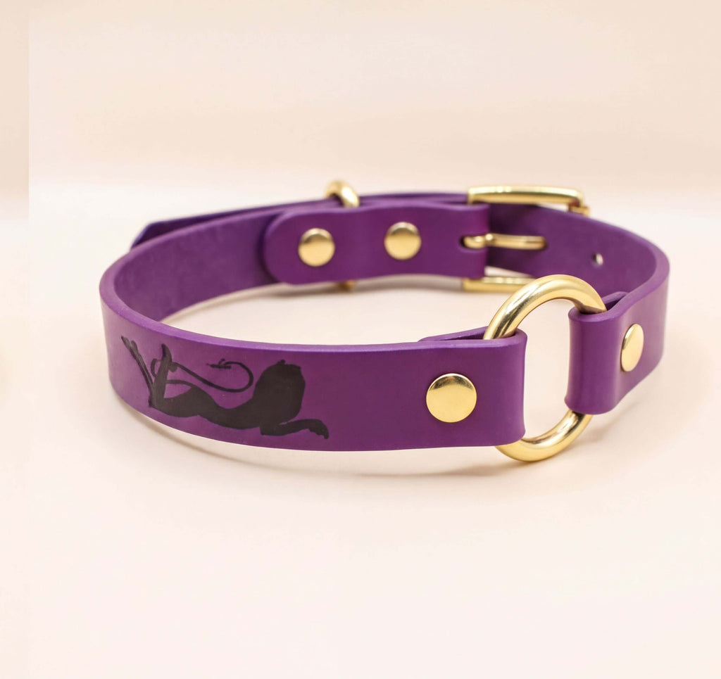 A purple leather dog collar with a gold buckle and a black silhouette of a dog.