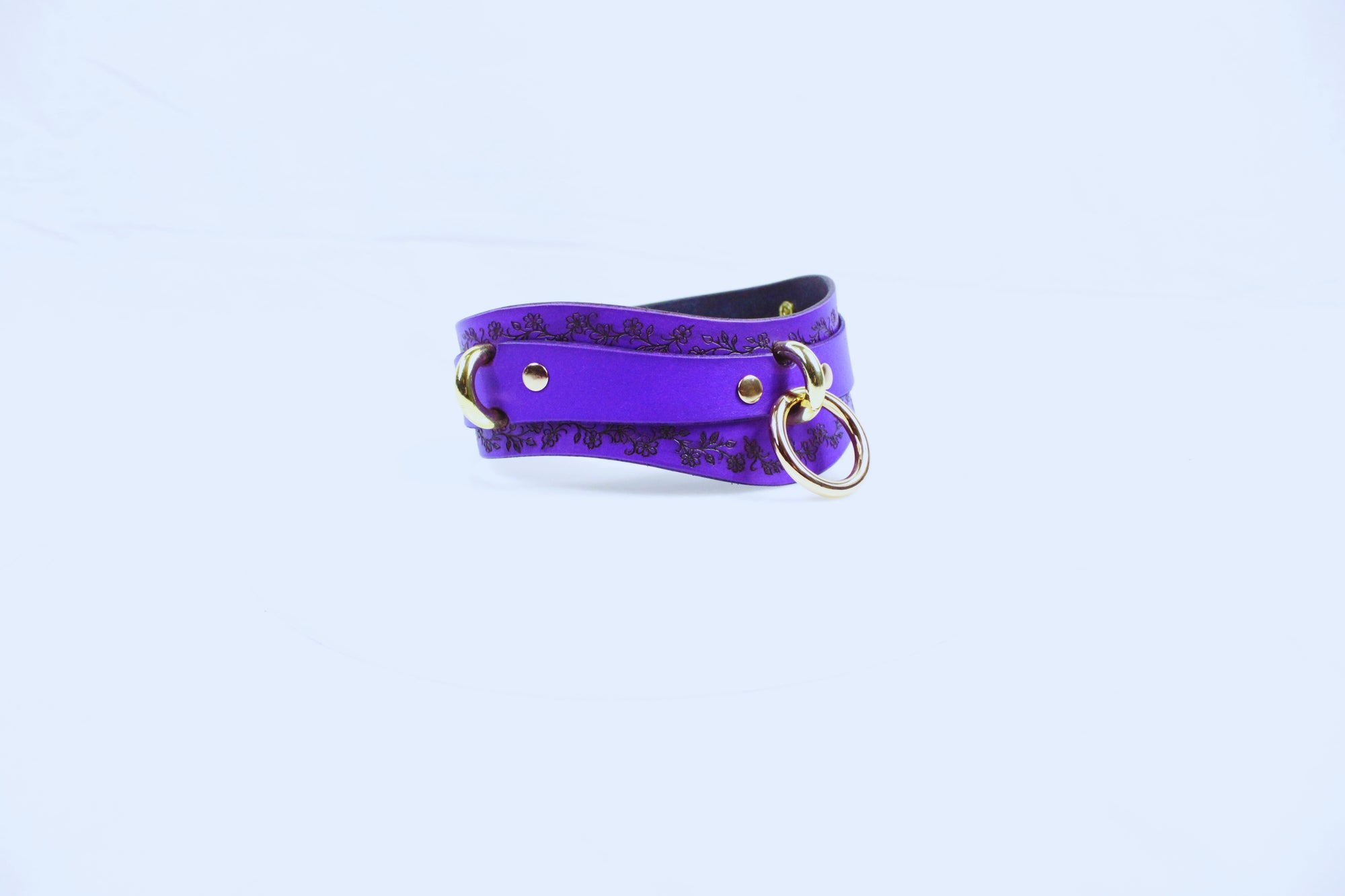 A purple leather choker necklace with a gold-colored metal clasp and ring.