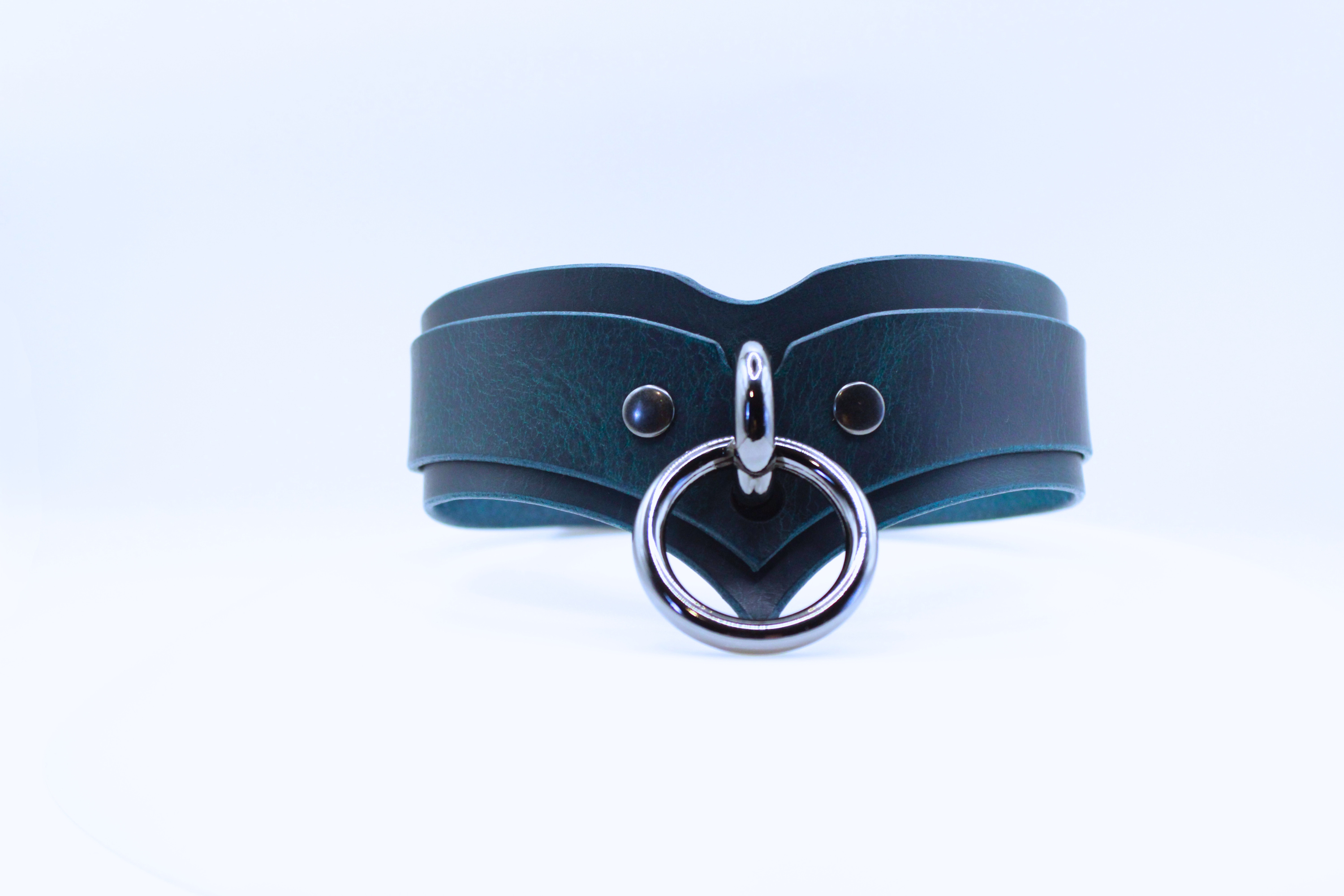 A dark blue leather choker necklace with a silver metal ring and two small holes on the front.