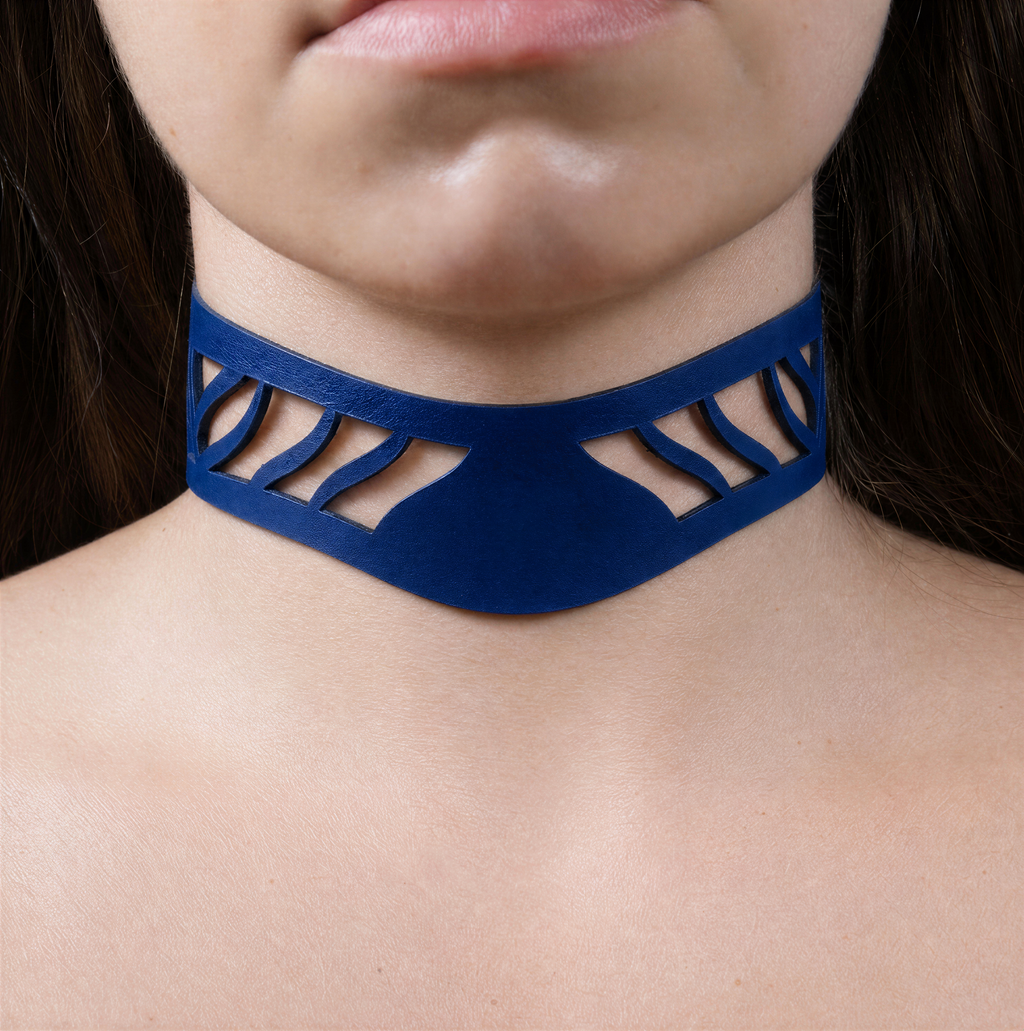 A close-up of a person's neck and chest area wearing a blue choker necklace with a unique cutout design.